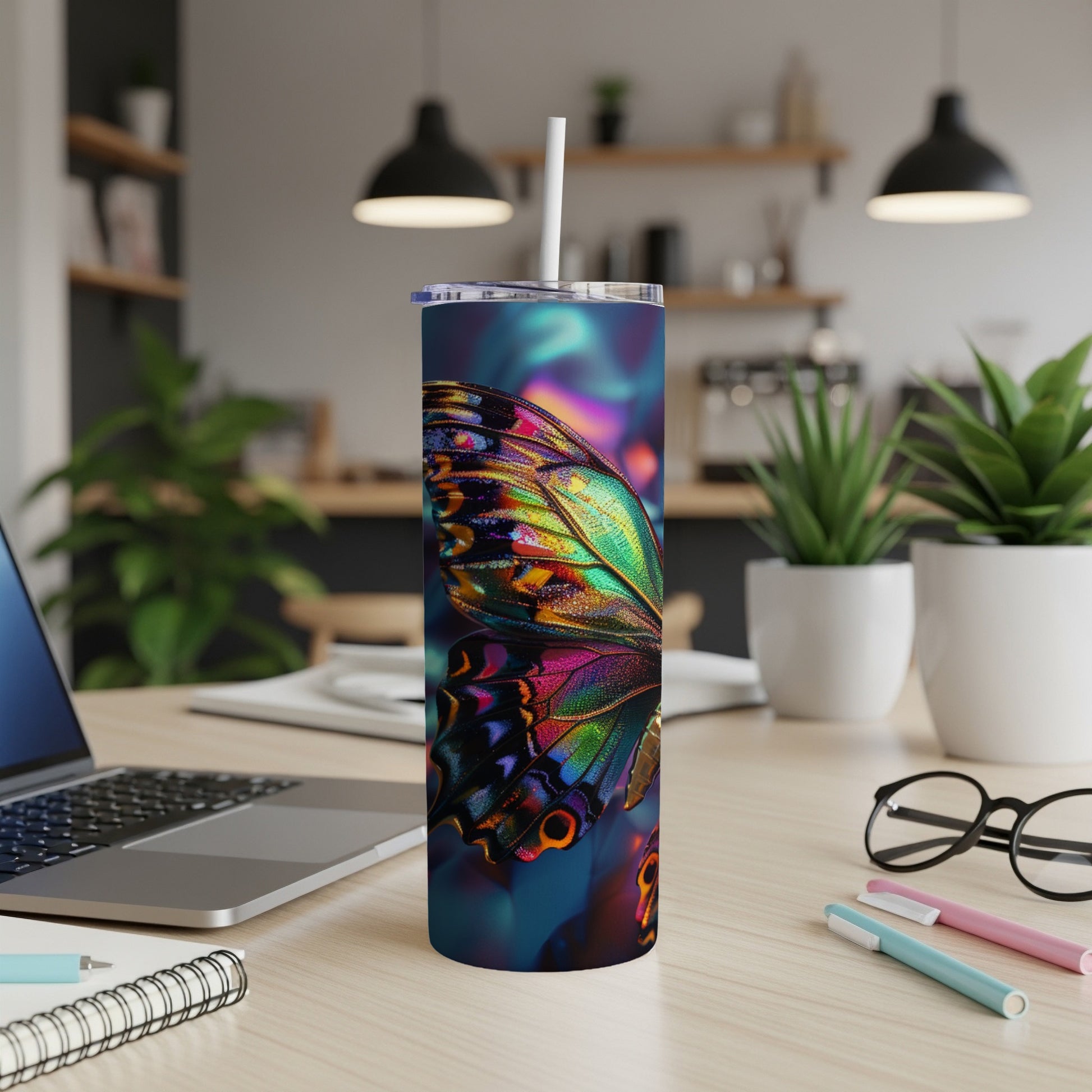 Colorful butterfly wing design on a skinny tumbler with a straw.