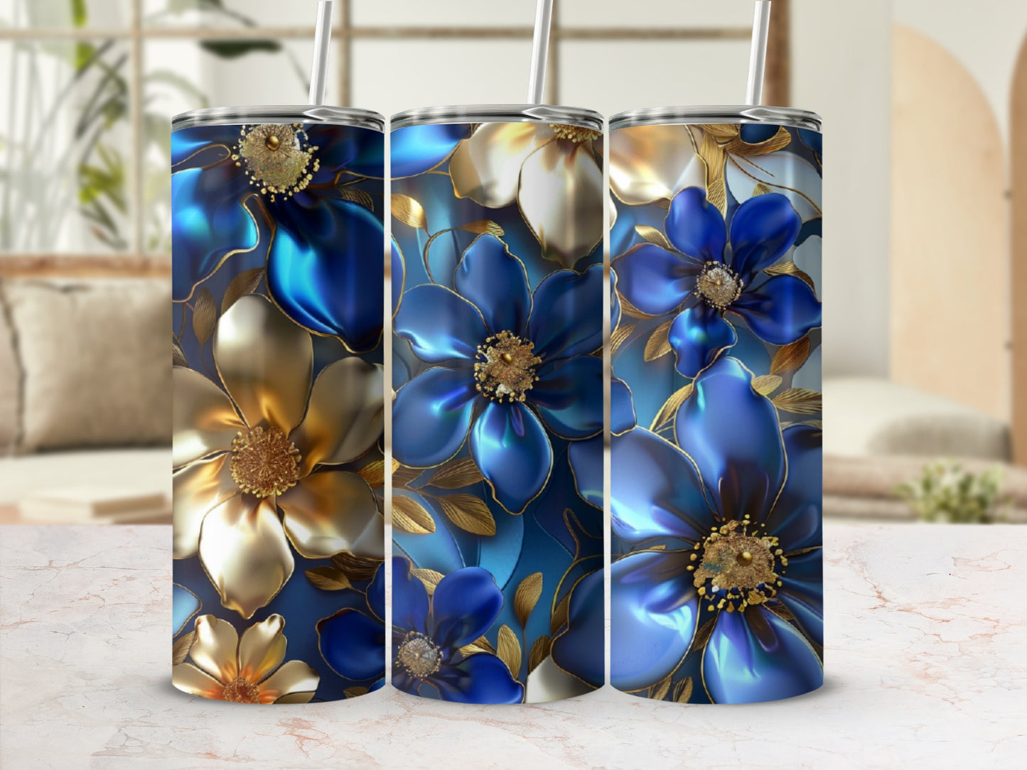 Three tumblers with blue and gold floral designs and straws.