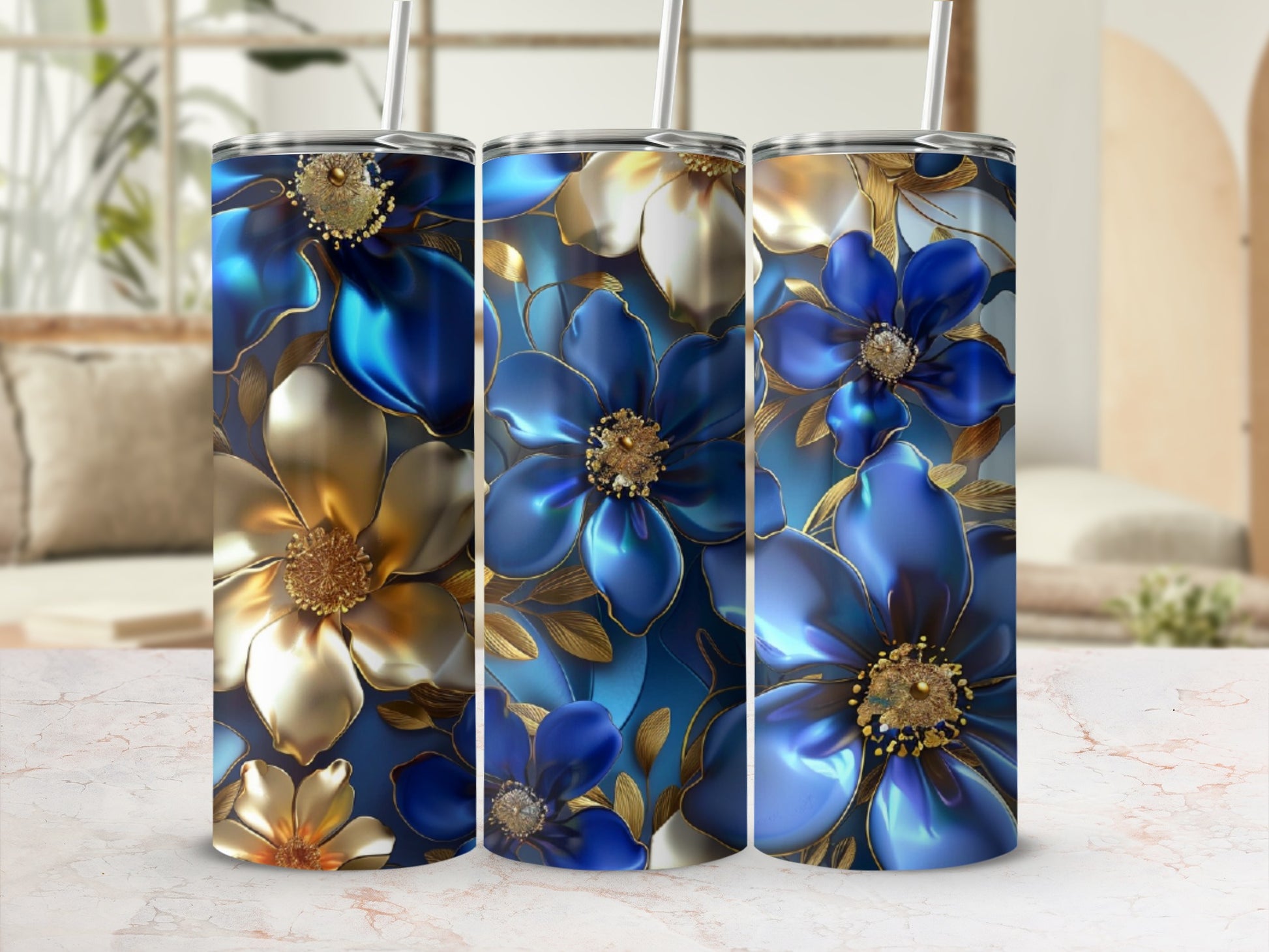 Three tumblers with blue and gold floral designs and straws.