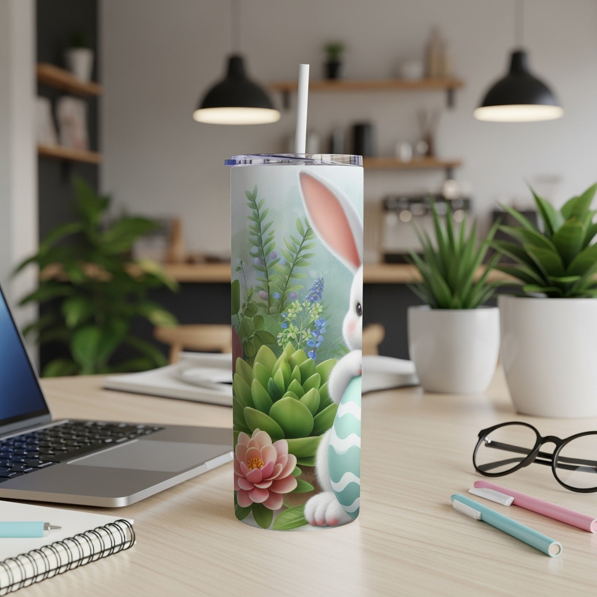 Easter bunny with an egg on a patterned tumbler with plants in background.