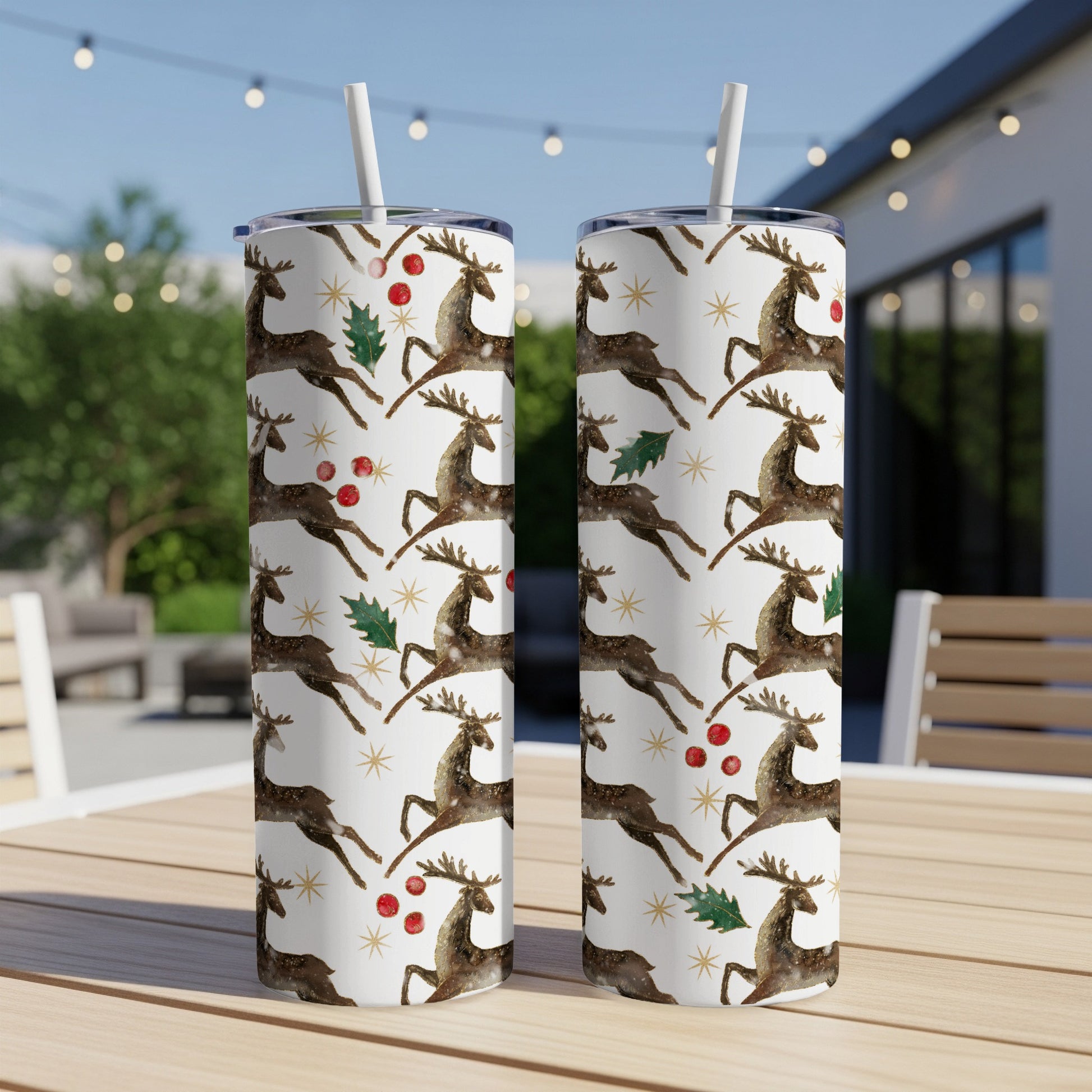 Two white tumblers with a repeating pattern of reindeer and holly.