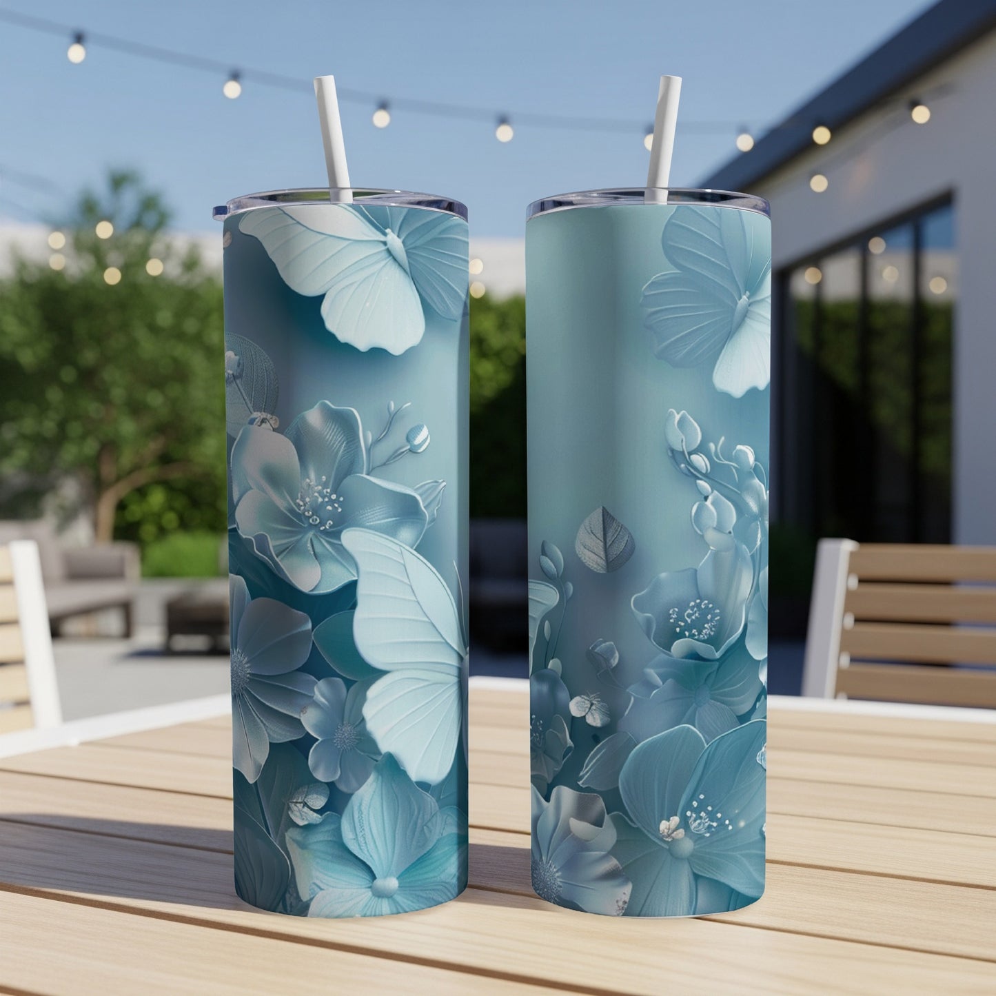 Two teal tumblers with delicate light blue floral and butterfly designs.