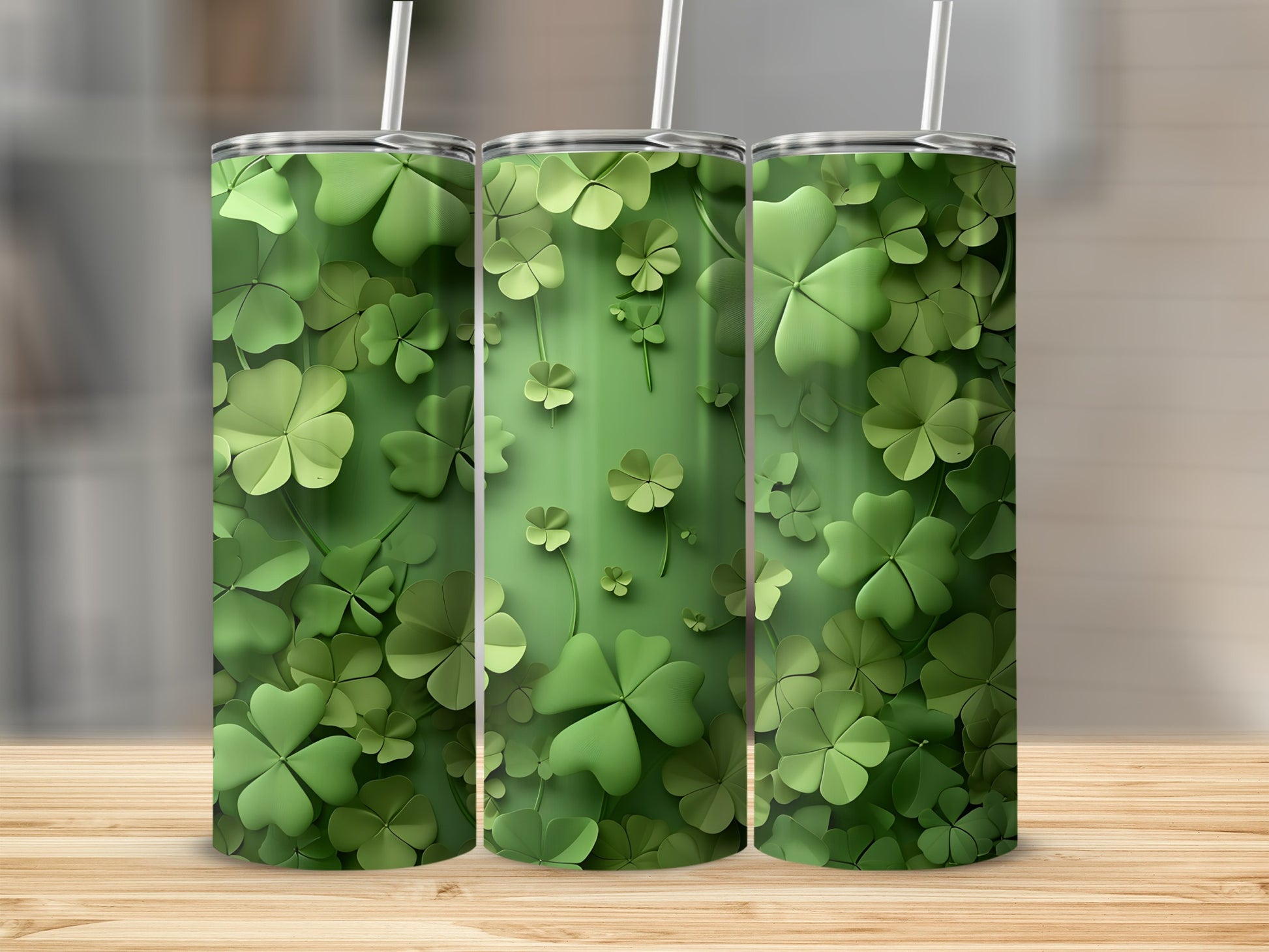 Three green tumblers with shamrock clover patterns on a wooden surface.