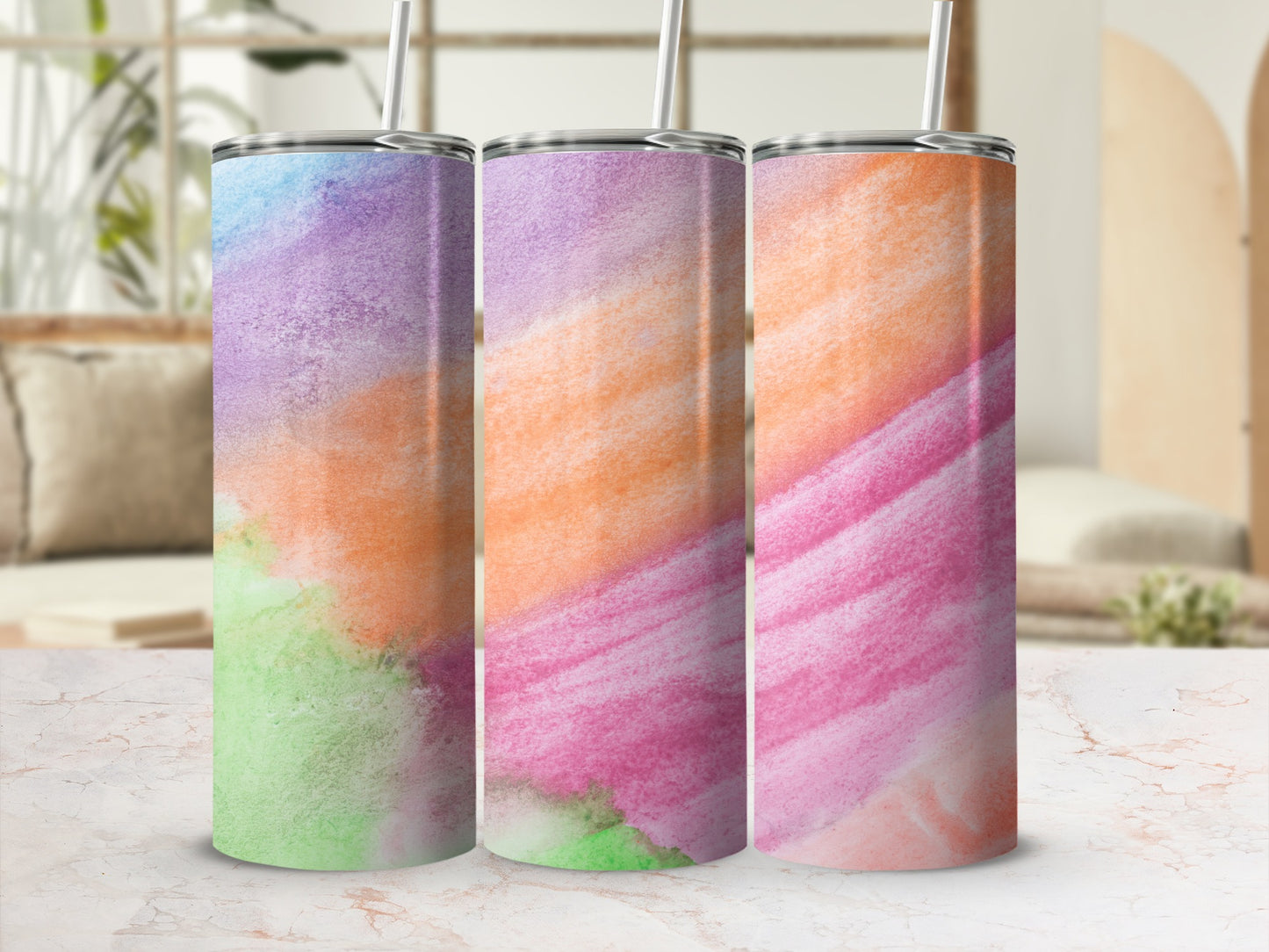 Three tumblers with watercolor designs in green, purple, orange, and pink.