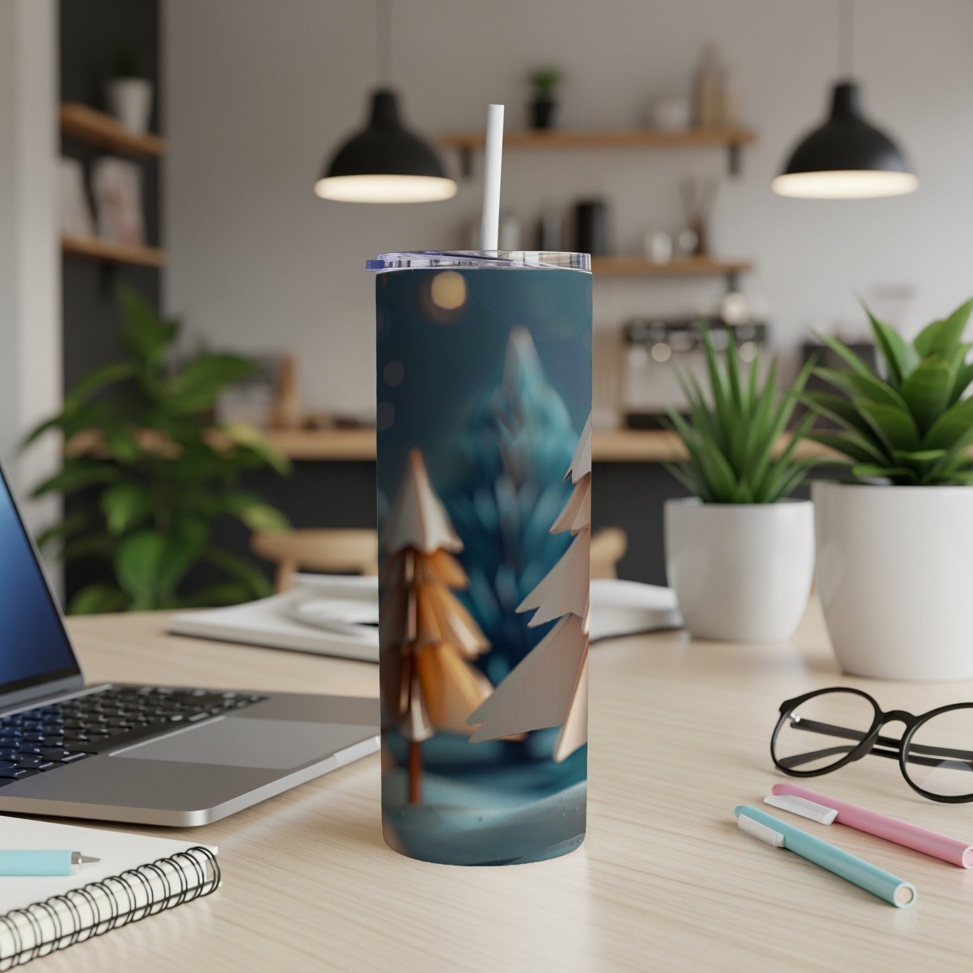 Paper Christmas trees on a blue, snowy background on a stainless steel tumbler.
