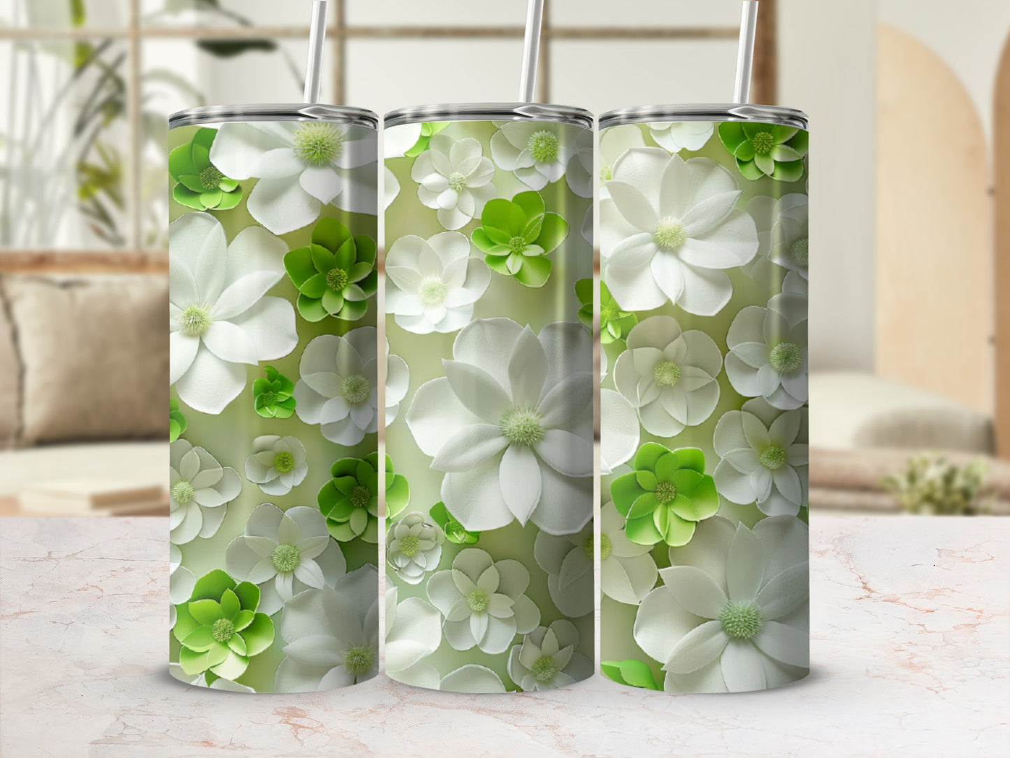 Three tumblers adorned with a pattern of white and green flowers.