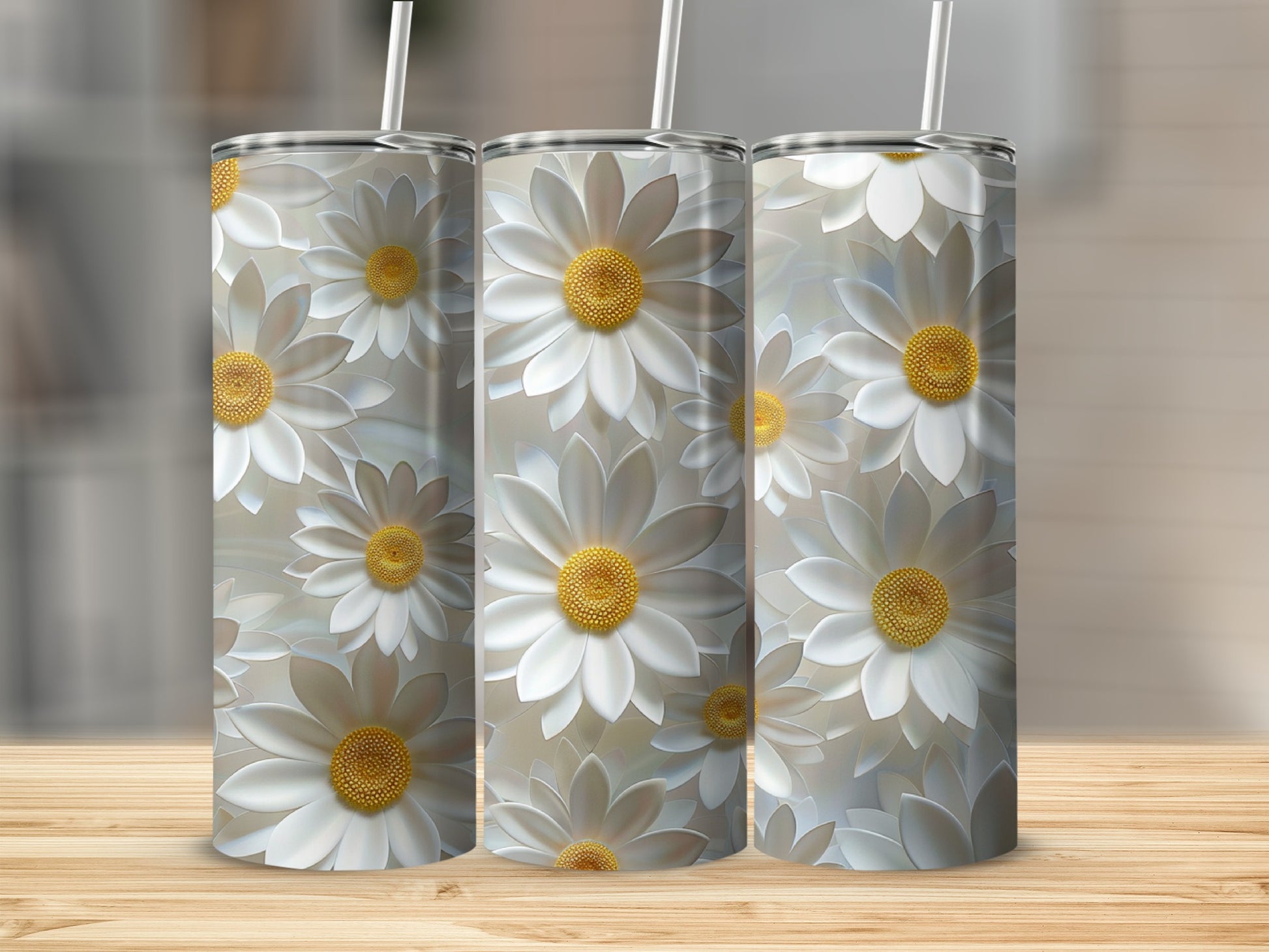 Three tumblers with white daisy flower patterns stand on a wooden surface.