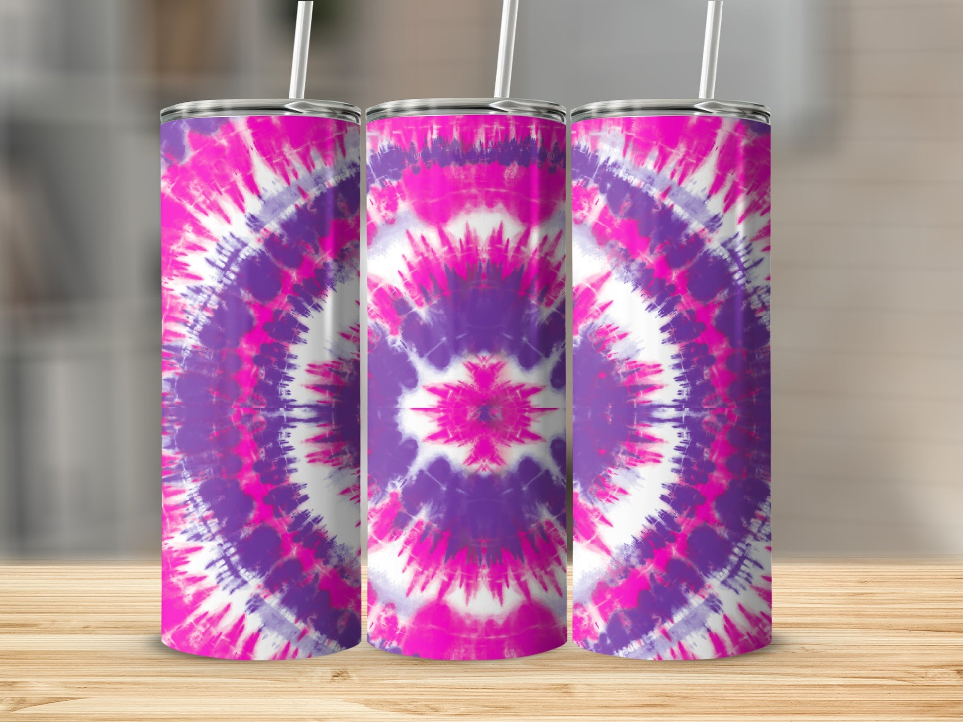 Three tumblers with a pink and purple tie-dye pattern are displayed on a wooden surface.