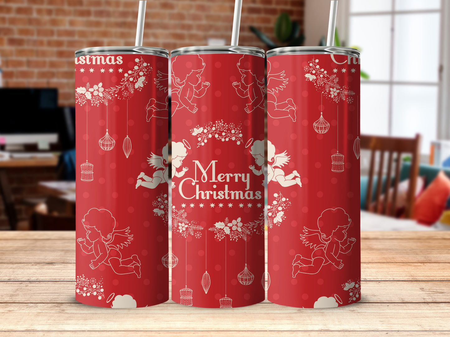 Red tumbler with white angels and "Merry Christmas" text, set on a wooden surface.