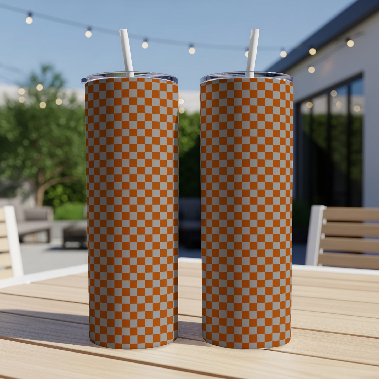 Two tall tumblers with orange and gray checkered pattern sit on a table.