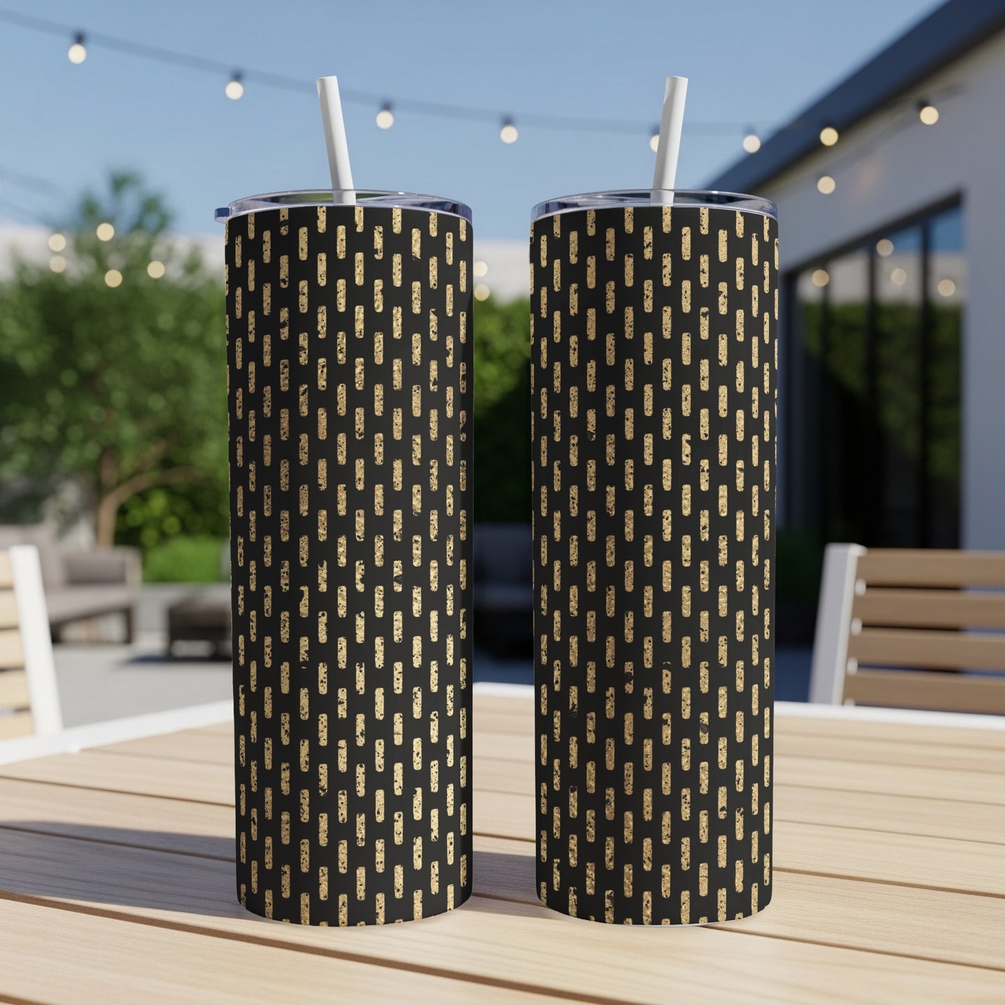 Two black tumblers with a speckled gold dash pattern, each with a straw.