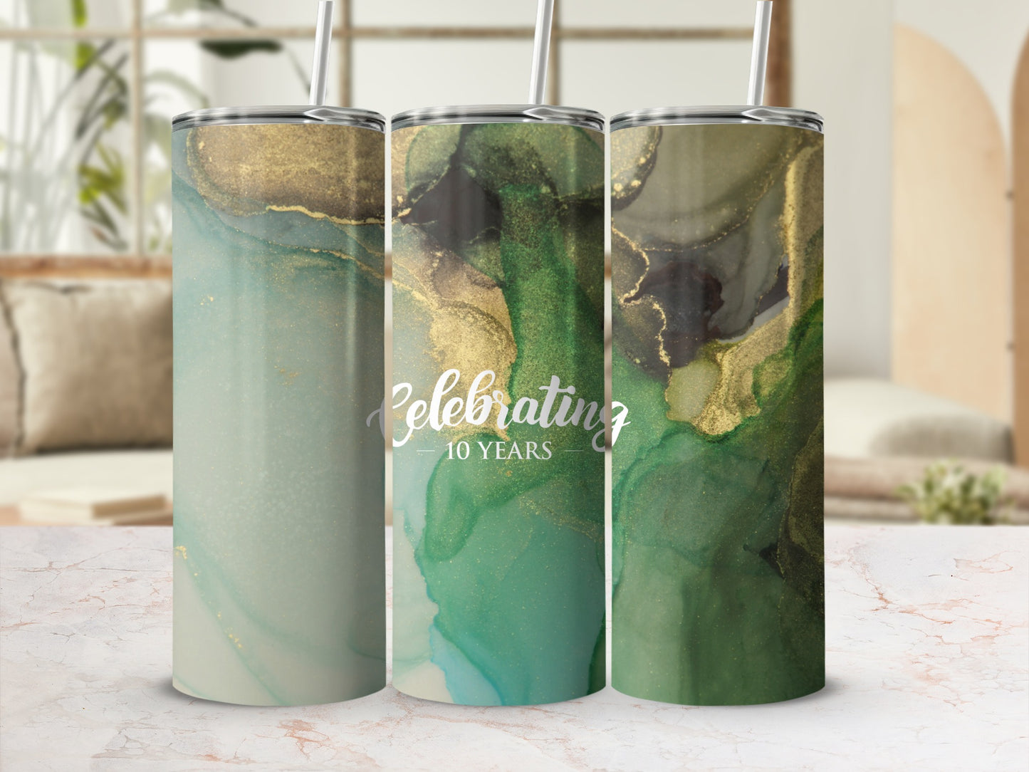 Three tumblers with marbled green and gold abstract design, one says "Celebrating 10 Years".