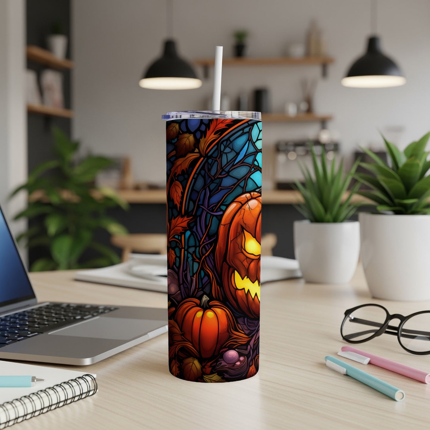 Tall tumbler with a stained-glass Halloween pumpkin design and straw.