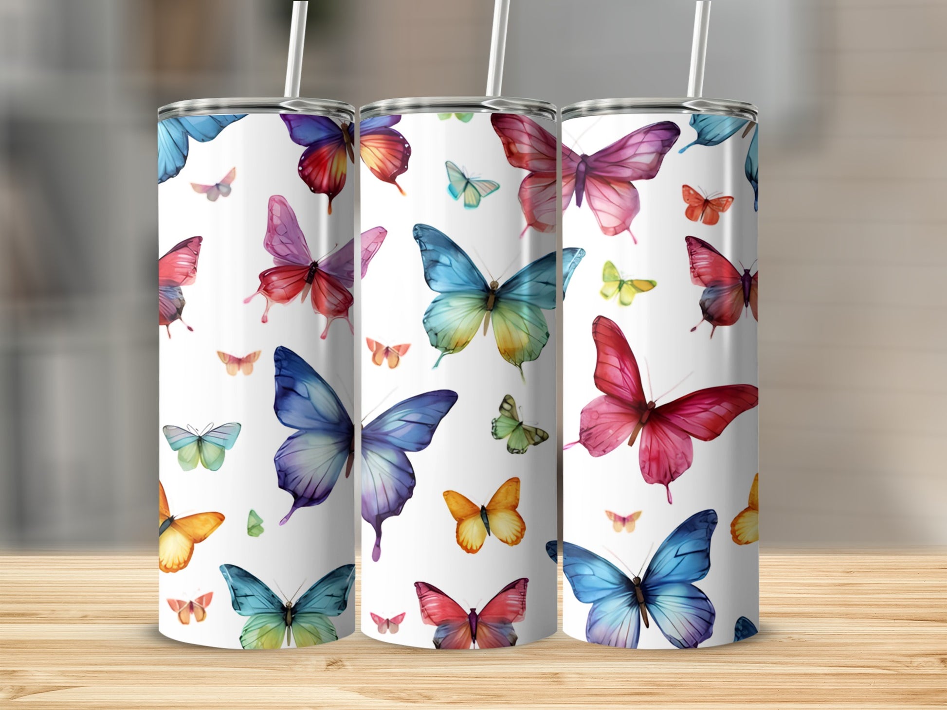 Three tumblers decorated with colorful watercolor butterflies.