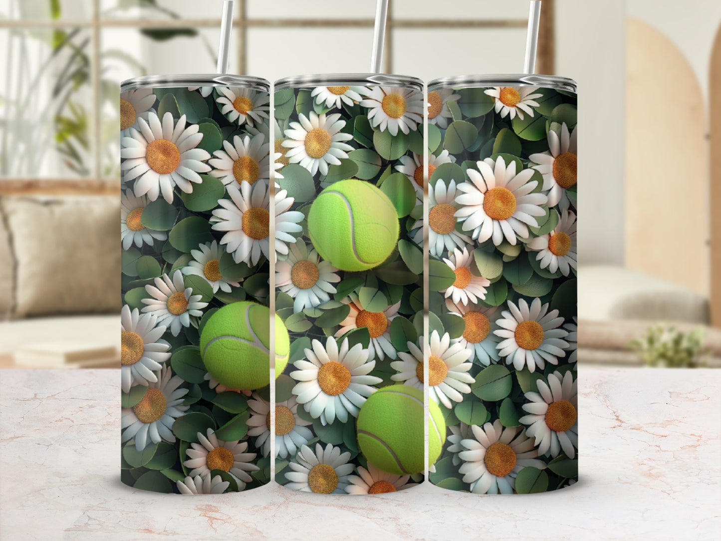 Three tumblers with a daisy and tennis ball pattern on a marble surface.