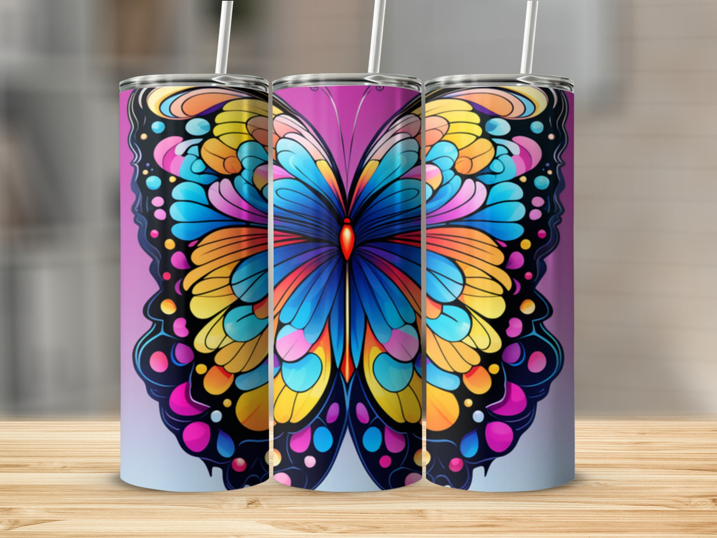Three tumblers with colorful butterfly designs stand on a wooden surface.
