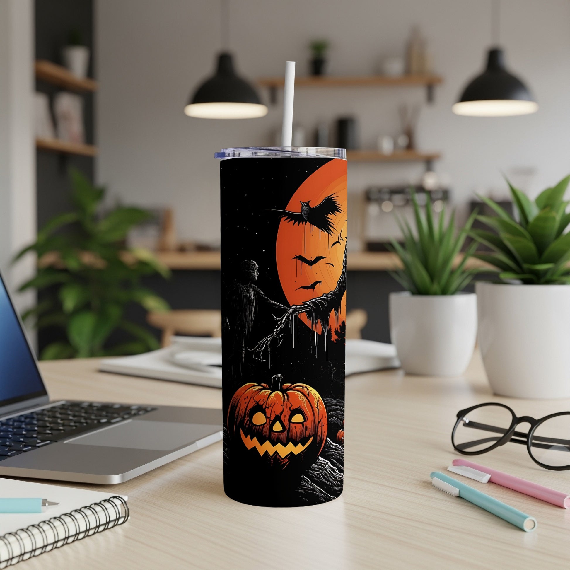 Tall black tumbler with Halloween design of pumpkin, scarecrow, bats, and owl against an orange moon.