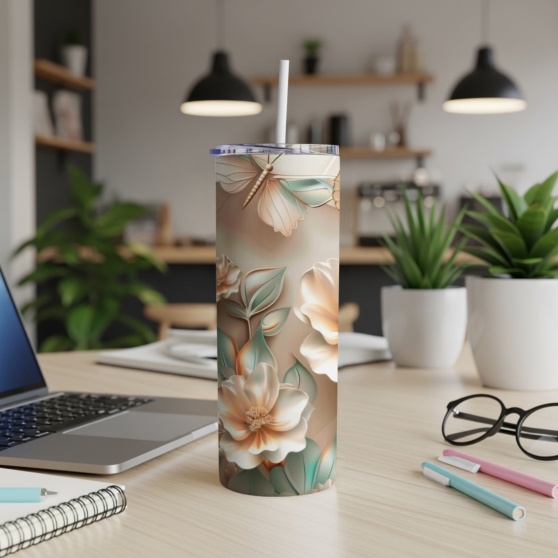Floral butterfly pattern on a white tumbler with a straw, on a desk.