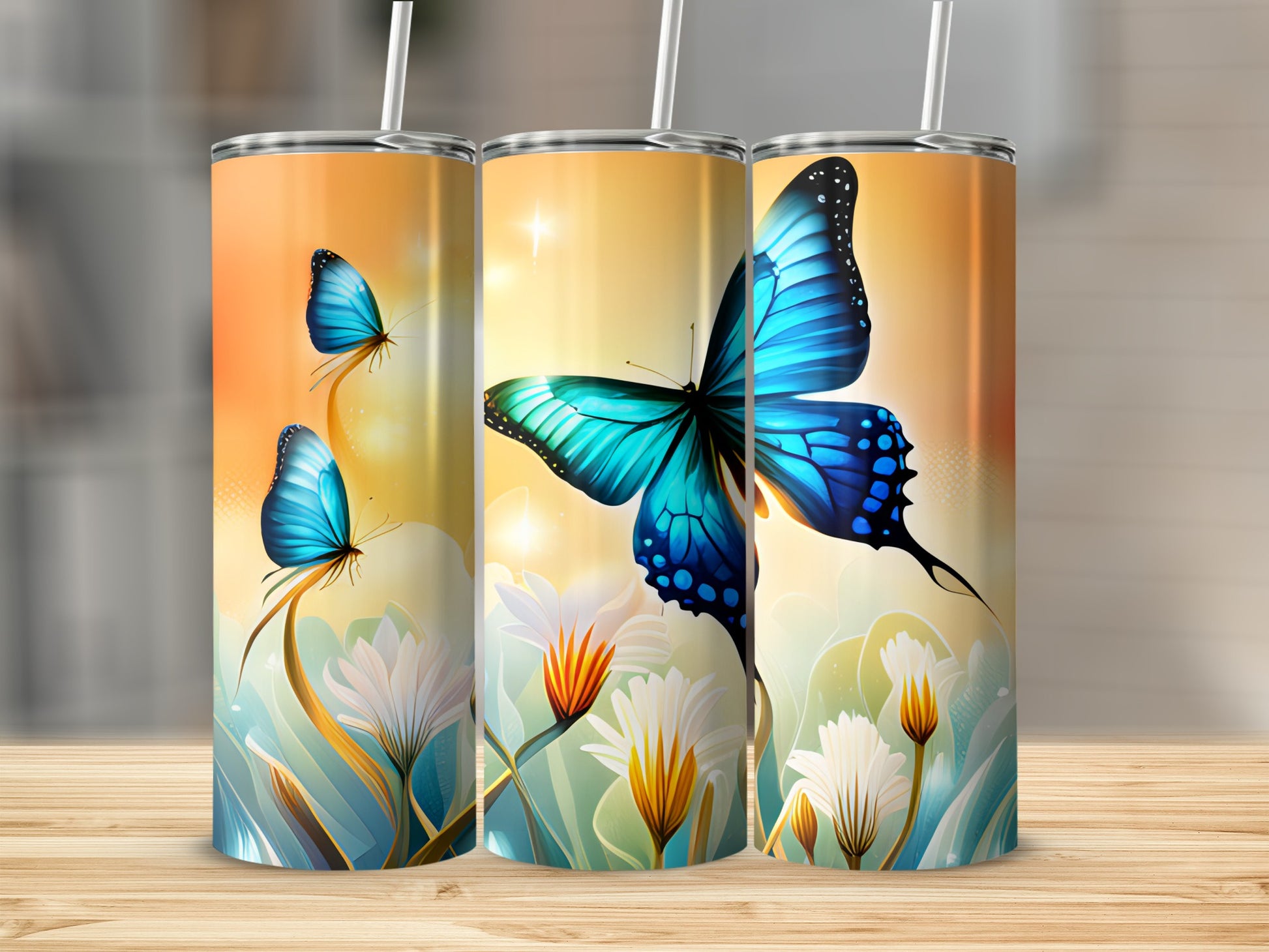 Three tumblers with blue butterflies and white flowers on a wooden surface.
