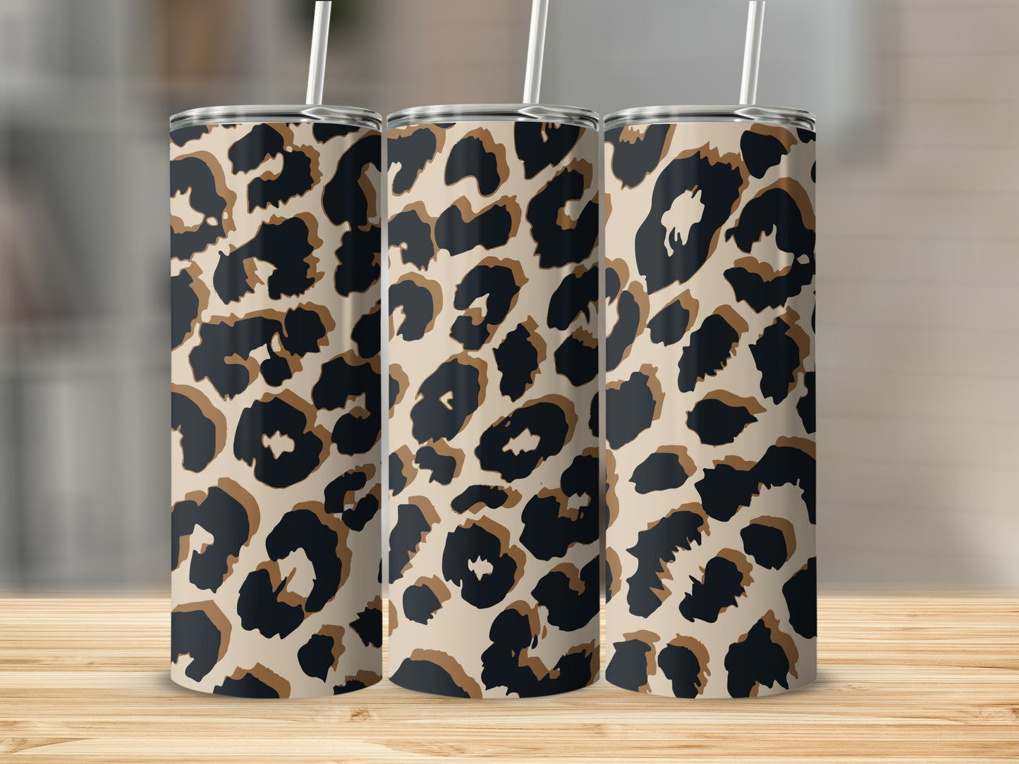Three tall tumblers with a leopard print design and white straws.