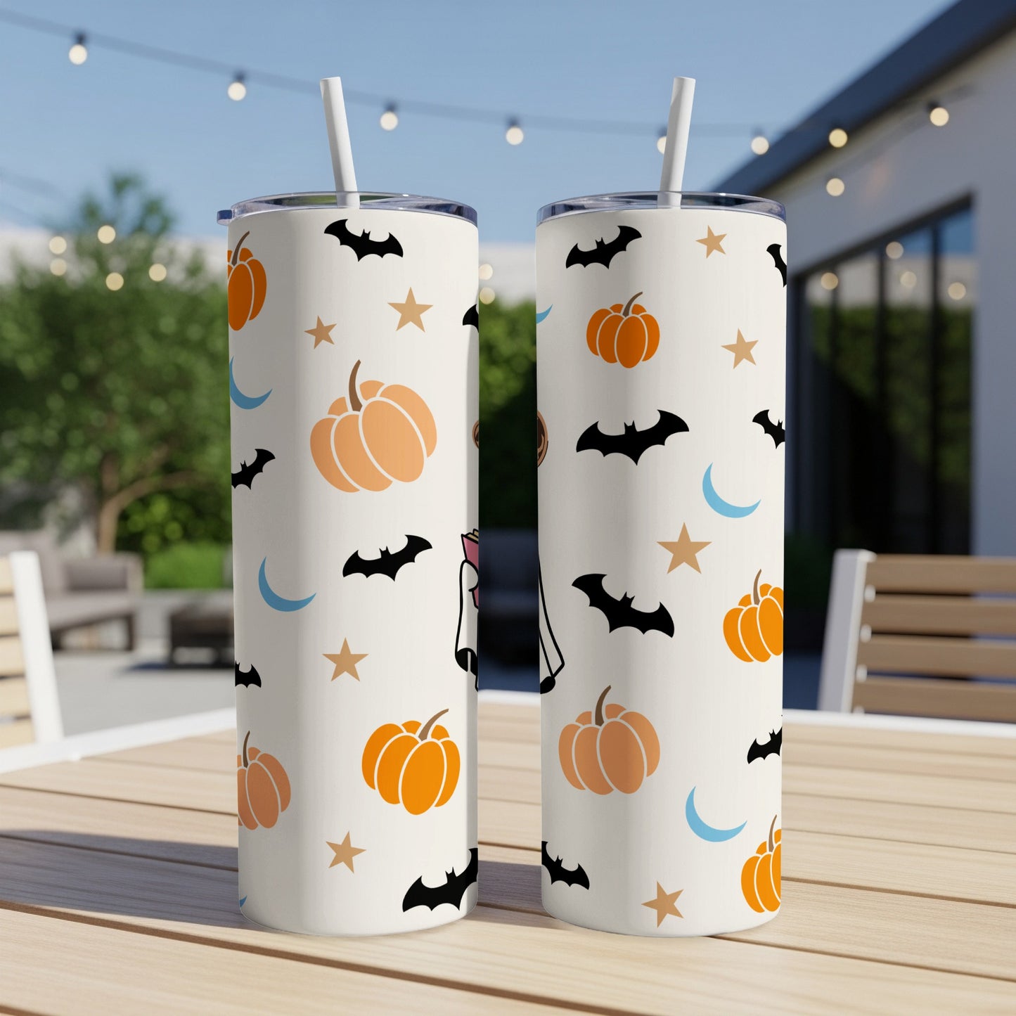 Two white tumblers with a Halloween pattern of pumpkins, bats, moons, and stars.