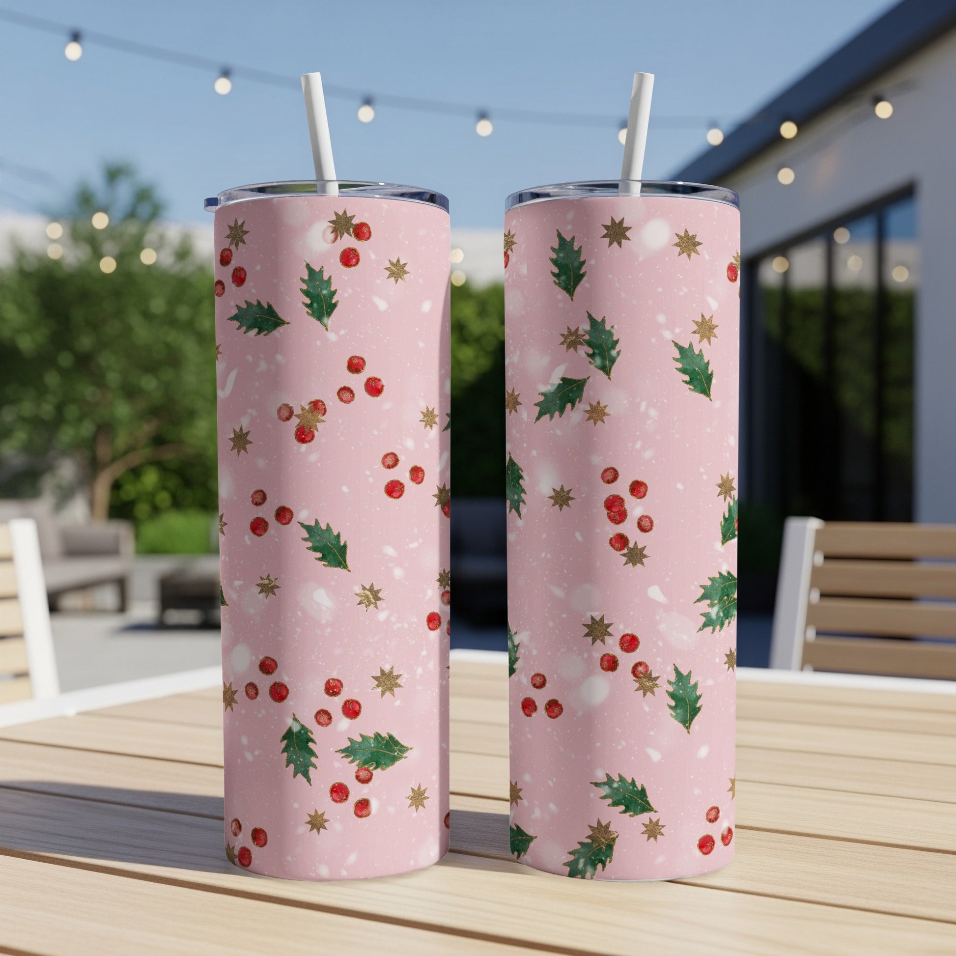 Two pink tumblers with holly and berry pattern.