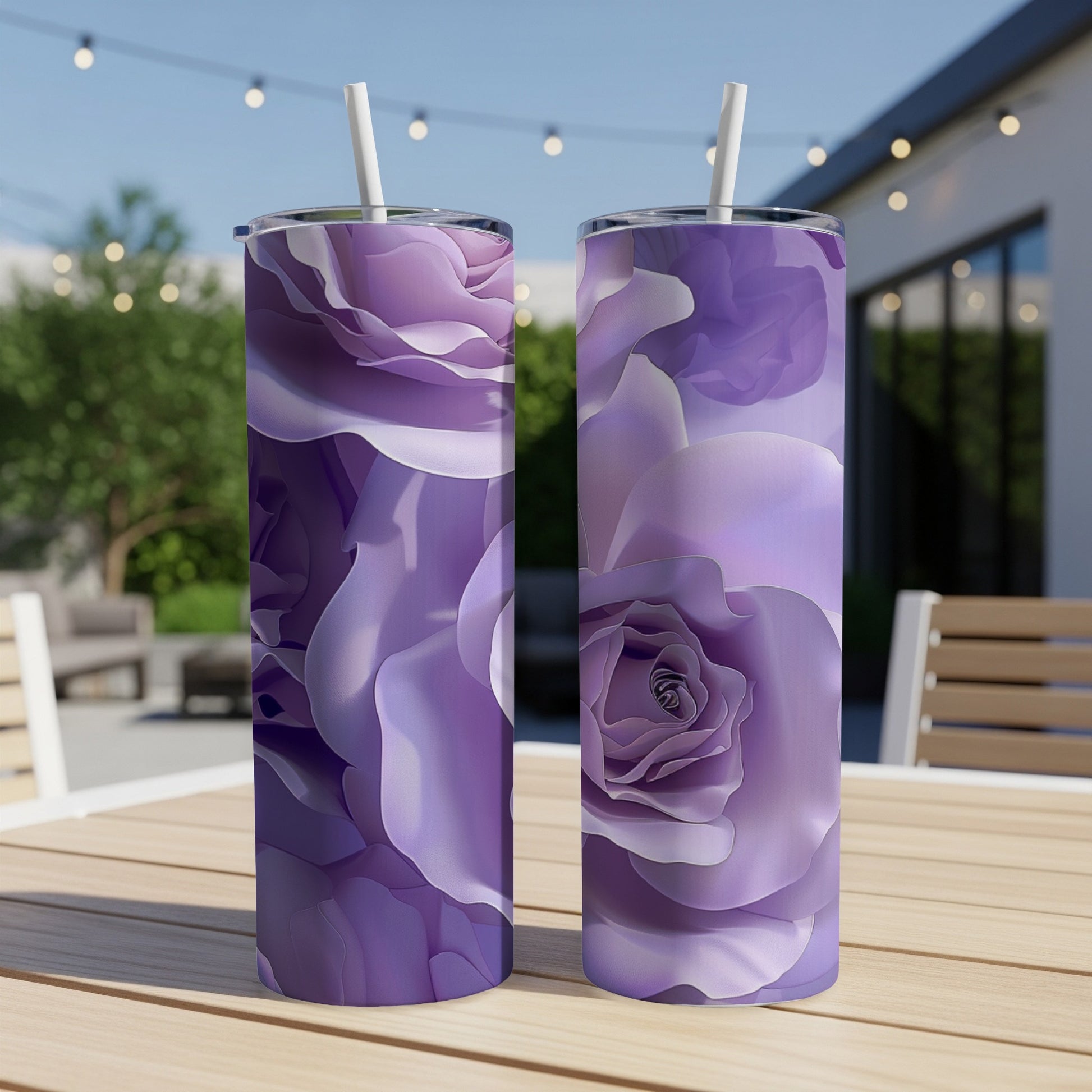Two tall purple floral tumblers with straws on a wooden table outdoors.