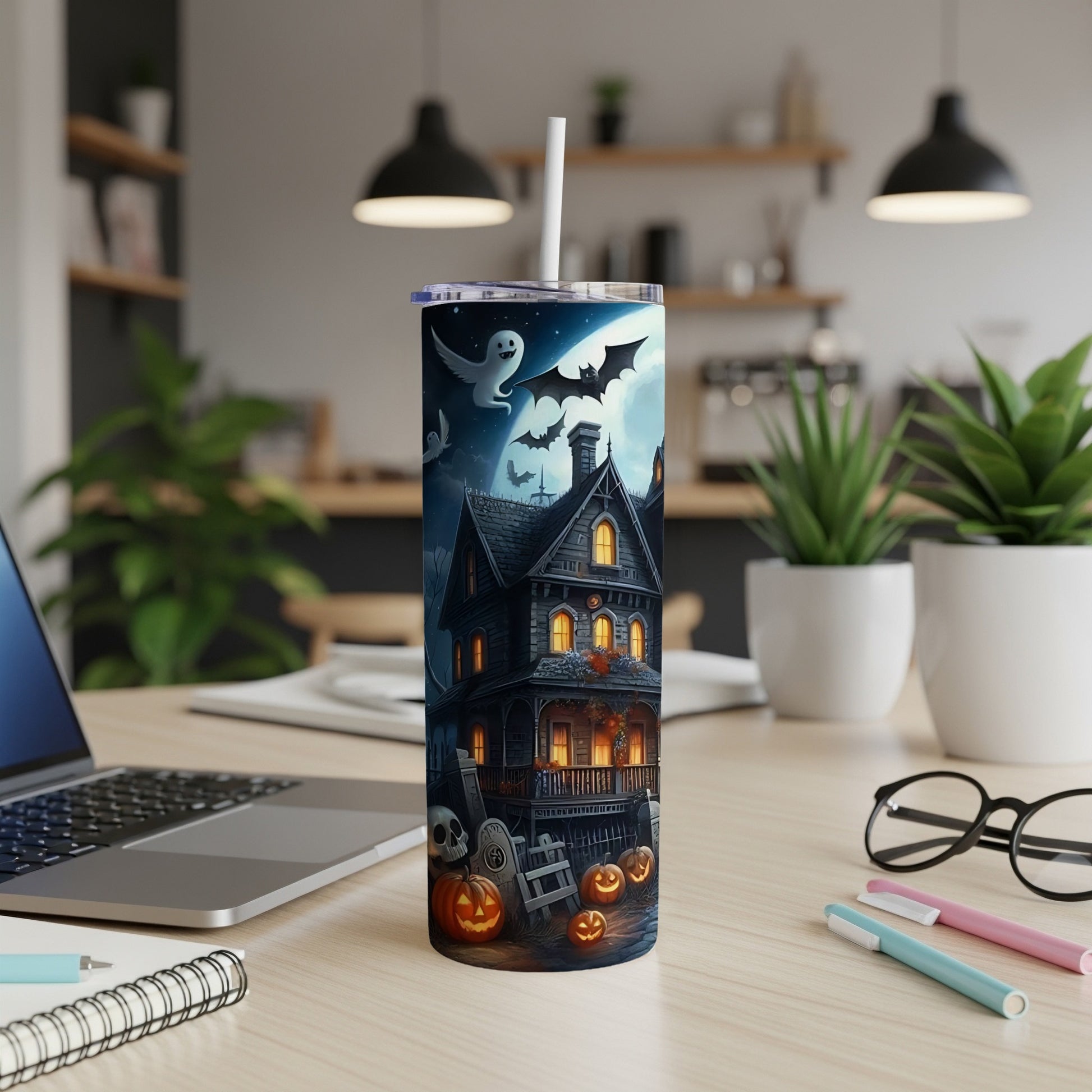 Tall tumbler with Halloween scene: haunted house, ghost, bats, pumpkins, and skull.
