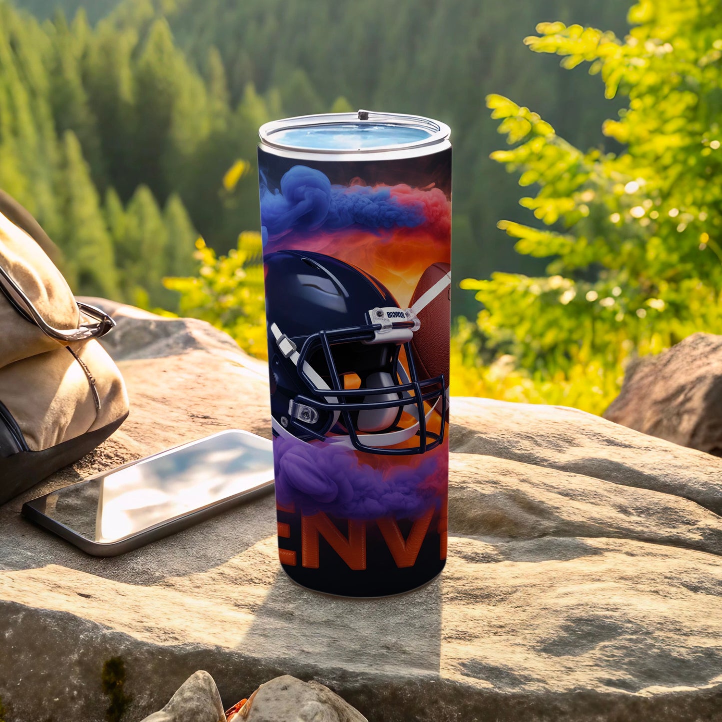 Football helmet and ball on tumbler with colorful smoke and outdoors background.