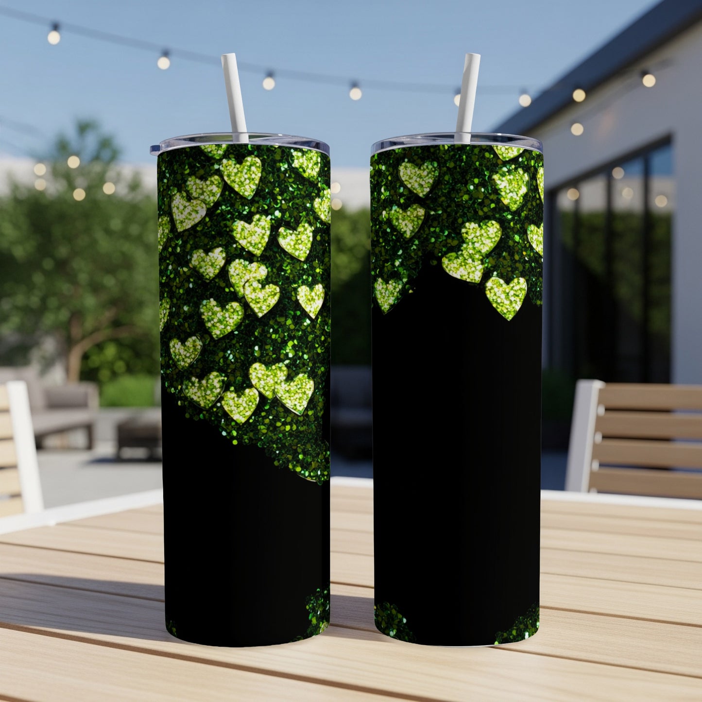 Two tumblers with green glitter heart pattern on black background.