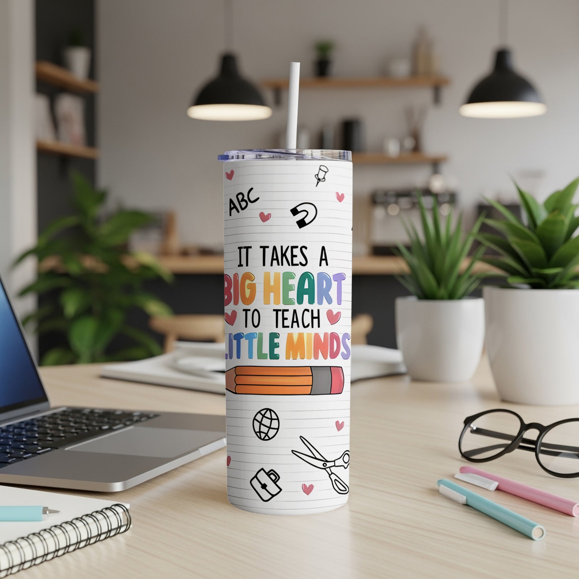 White tumbler with "It takes a big heart to teach little minds" and pencil illustration.
