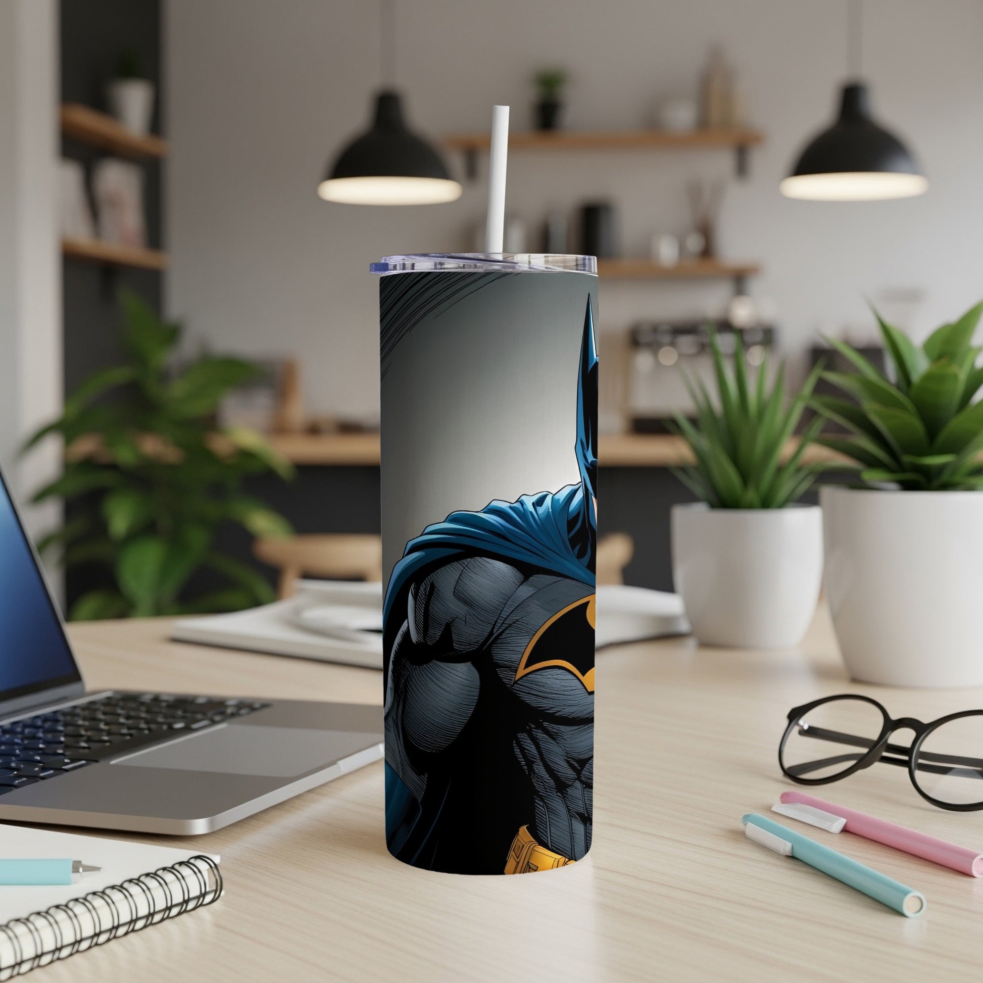 Batman character illustration on a white tumbler with straw, on a desk.