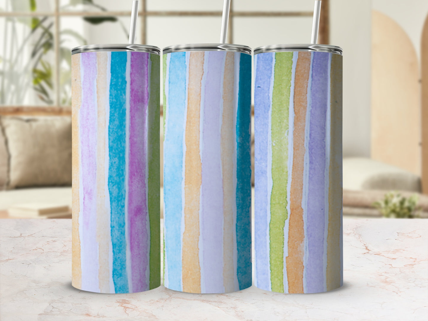 Three tumblers with pastel vertical stripes on a marble surface.