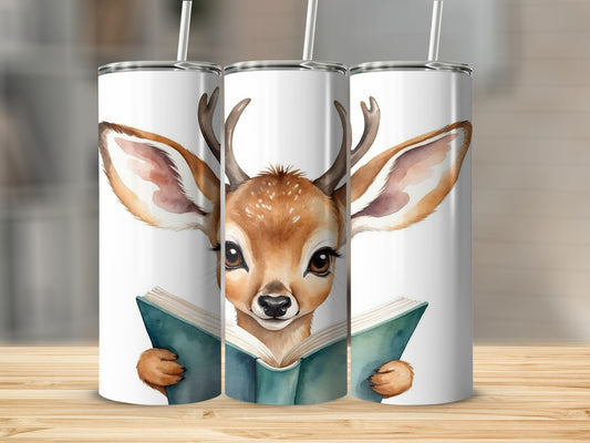 Deer wearing glasses reading a book on a white tumbler.
