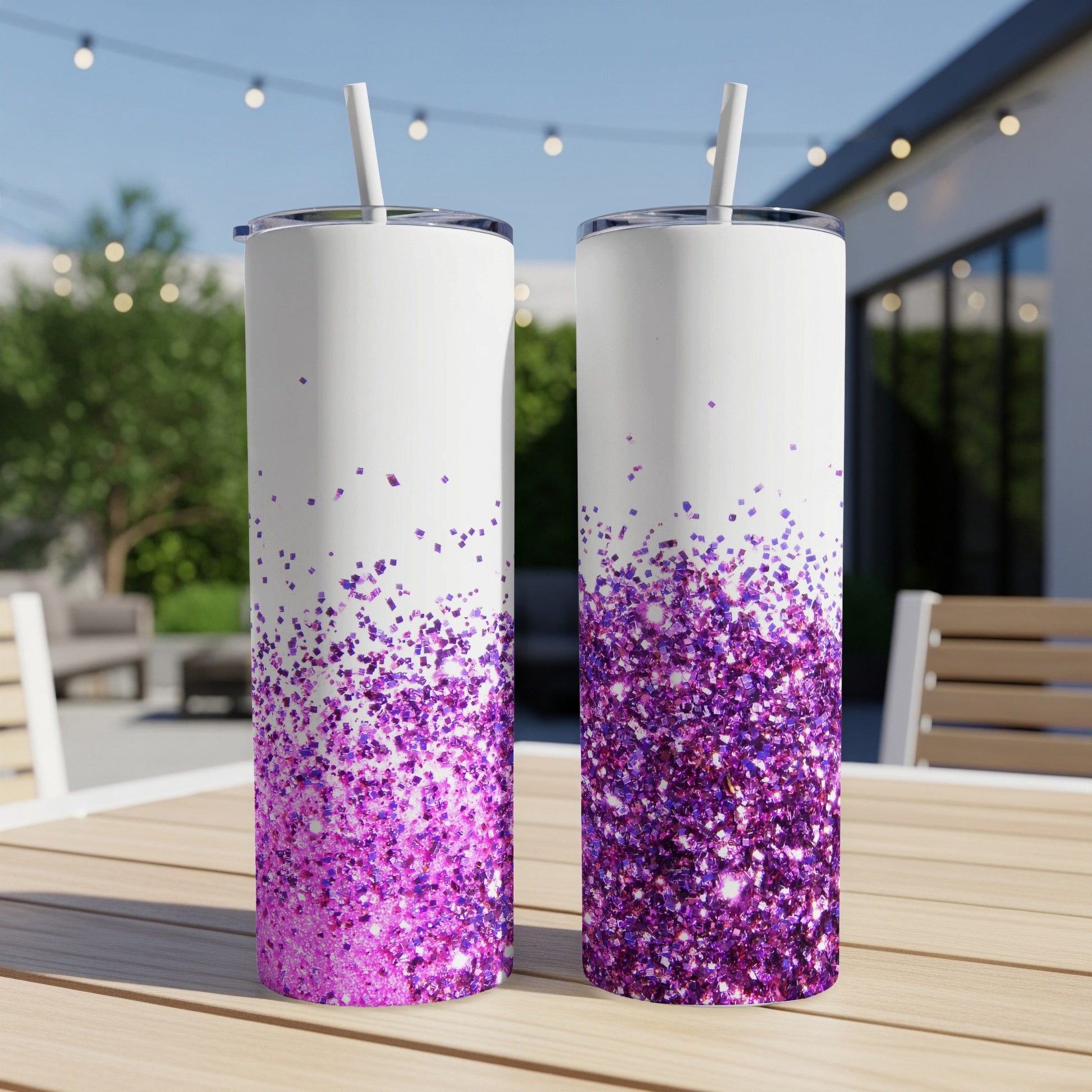 Two white tumblers with purple glitter gradient and straws on a table.