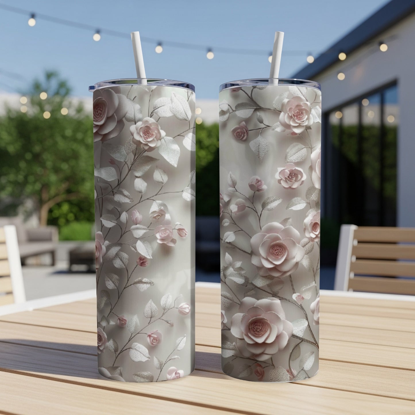 Two tall tumblers with a floral pattern of light pink roses and green leaves.