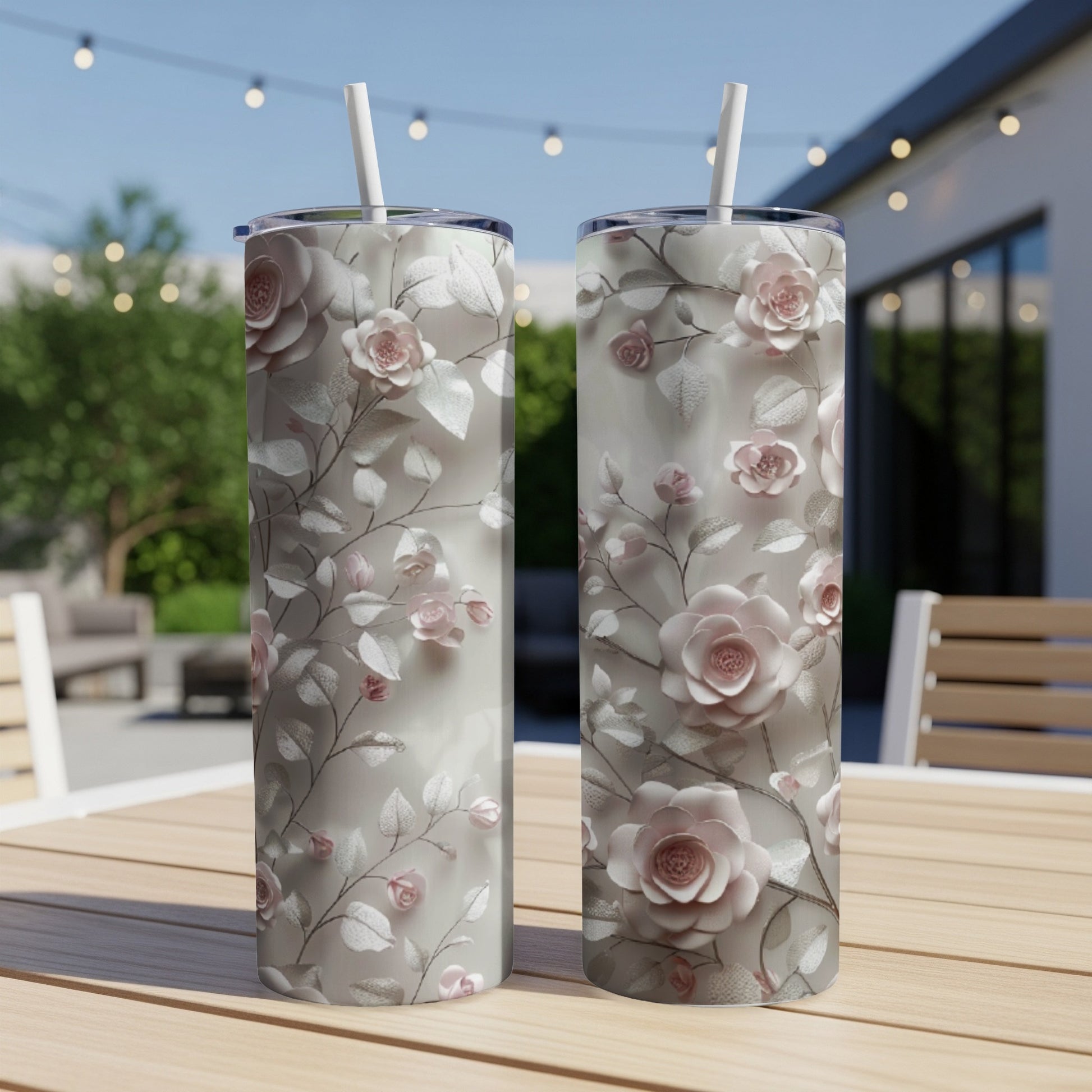 Two tall tumblers with a floral pattern of light pink roses and green leaves.