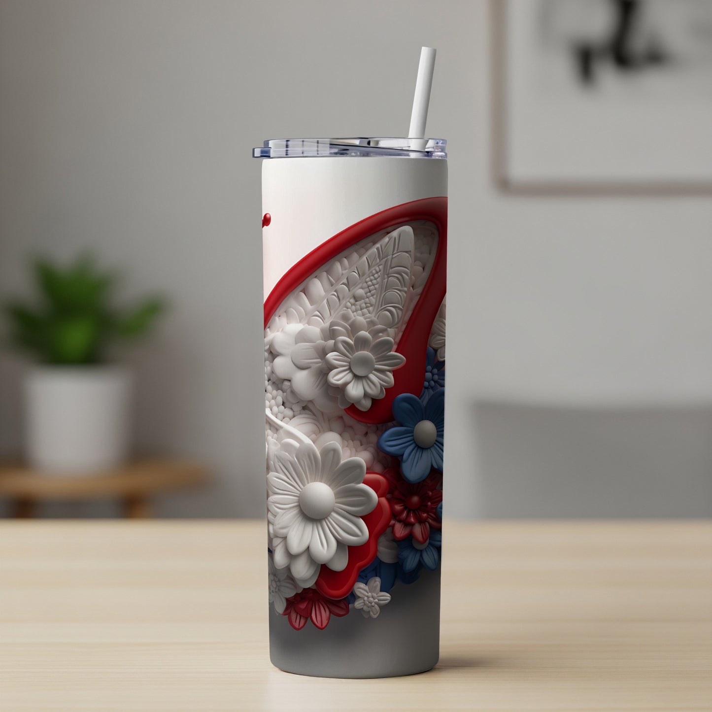 White and red tumbler with floral design and straw.