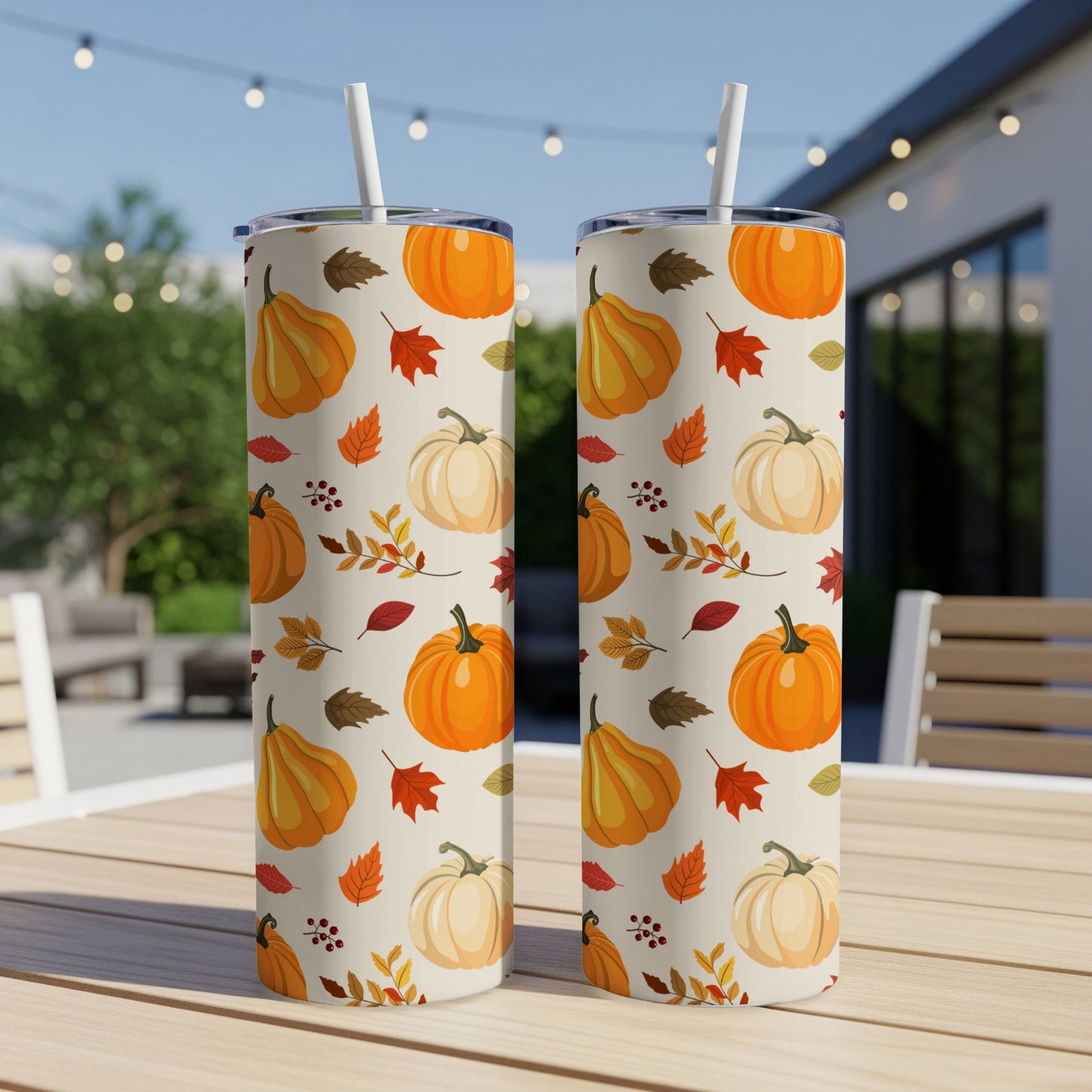 Two tumblers with a pumpkin and leaf fall pattern on a table.