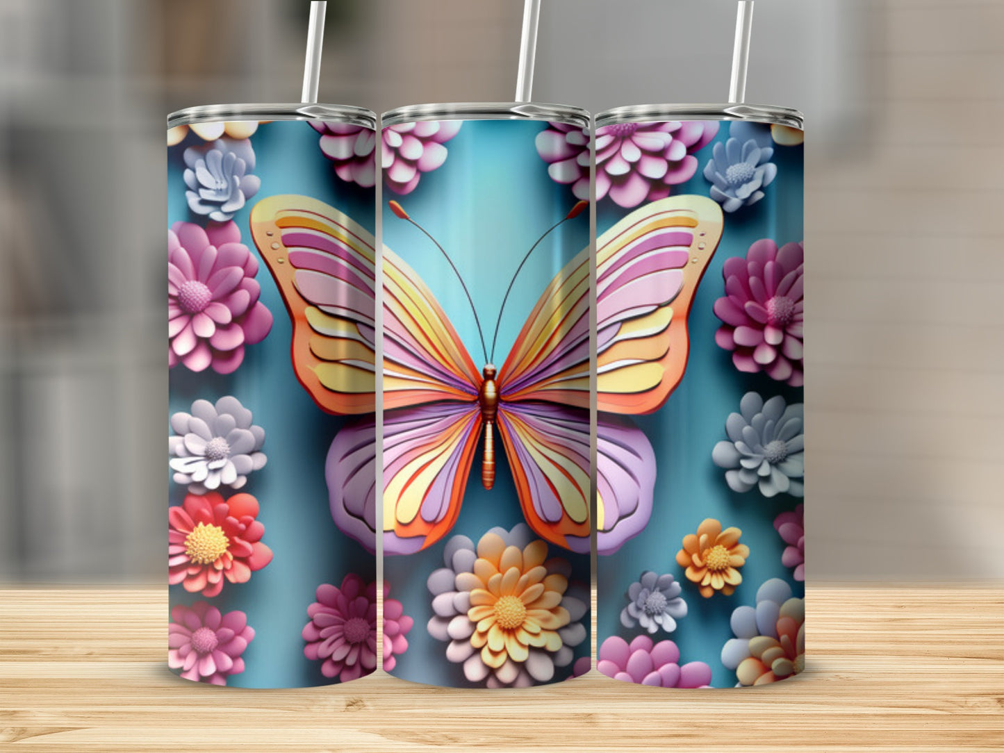 Three tumblers with colorful butterfly and floral designs on a blue background.