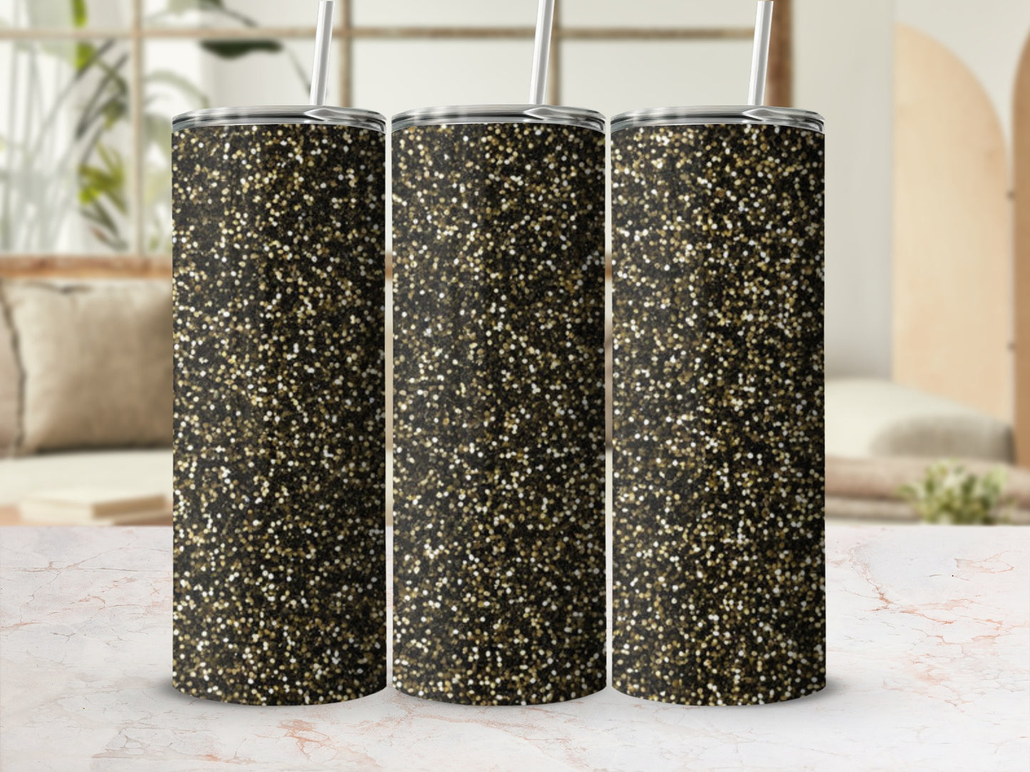 Three glitter tumblers with straw and lid on marbled surface.
