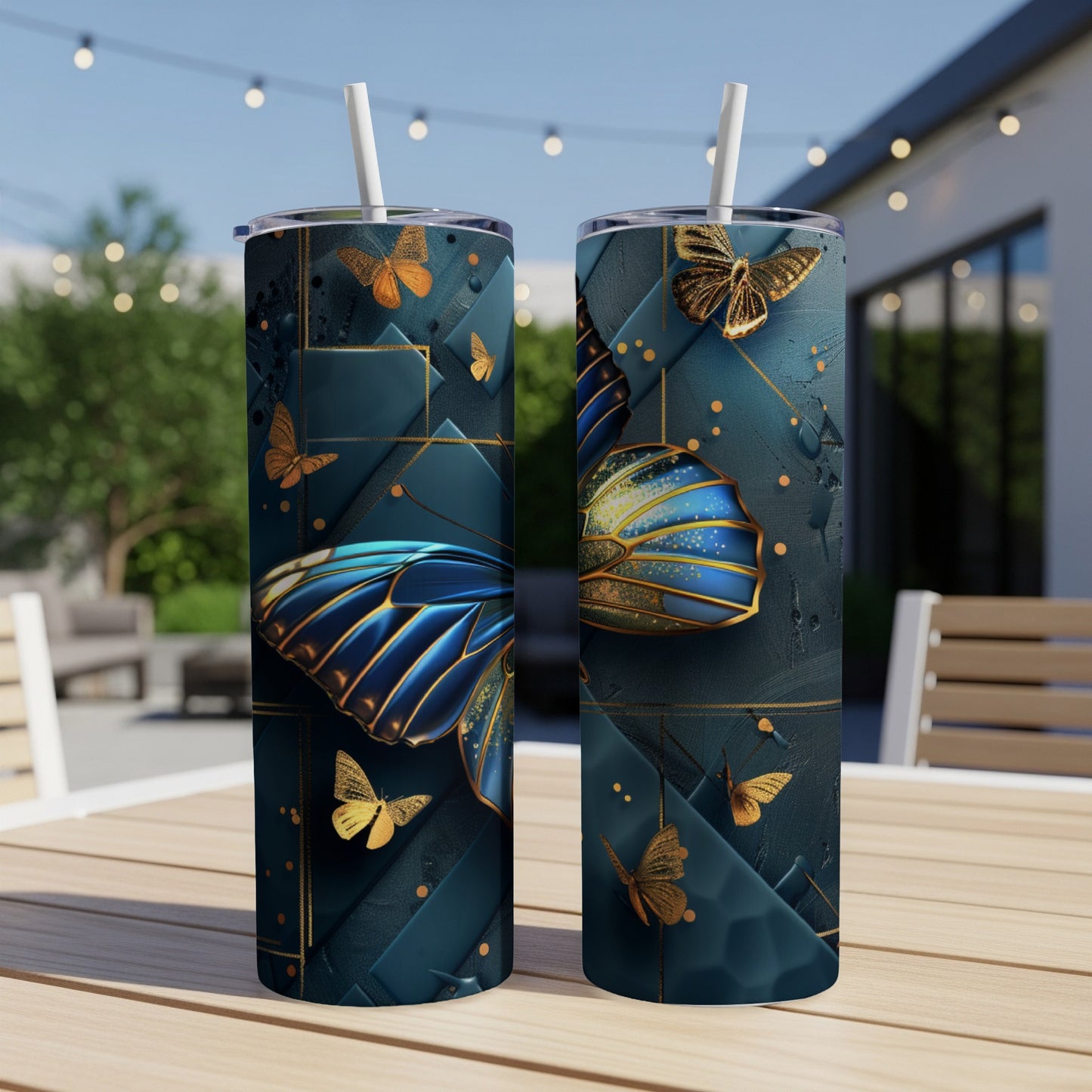 Two tumblers with ornate gold and blue butterfly design on a patio table.