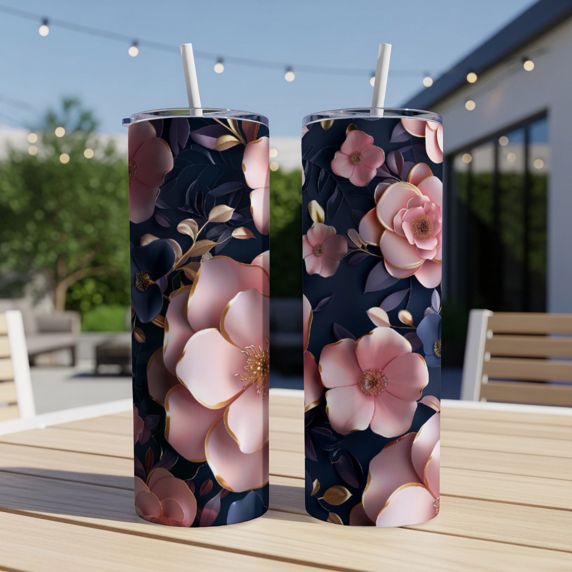 Two tumblers with a dark blue background and pink and gold floral pattern.