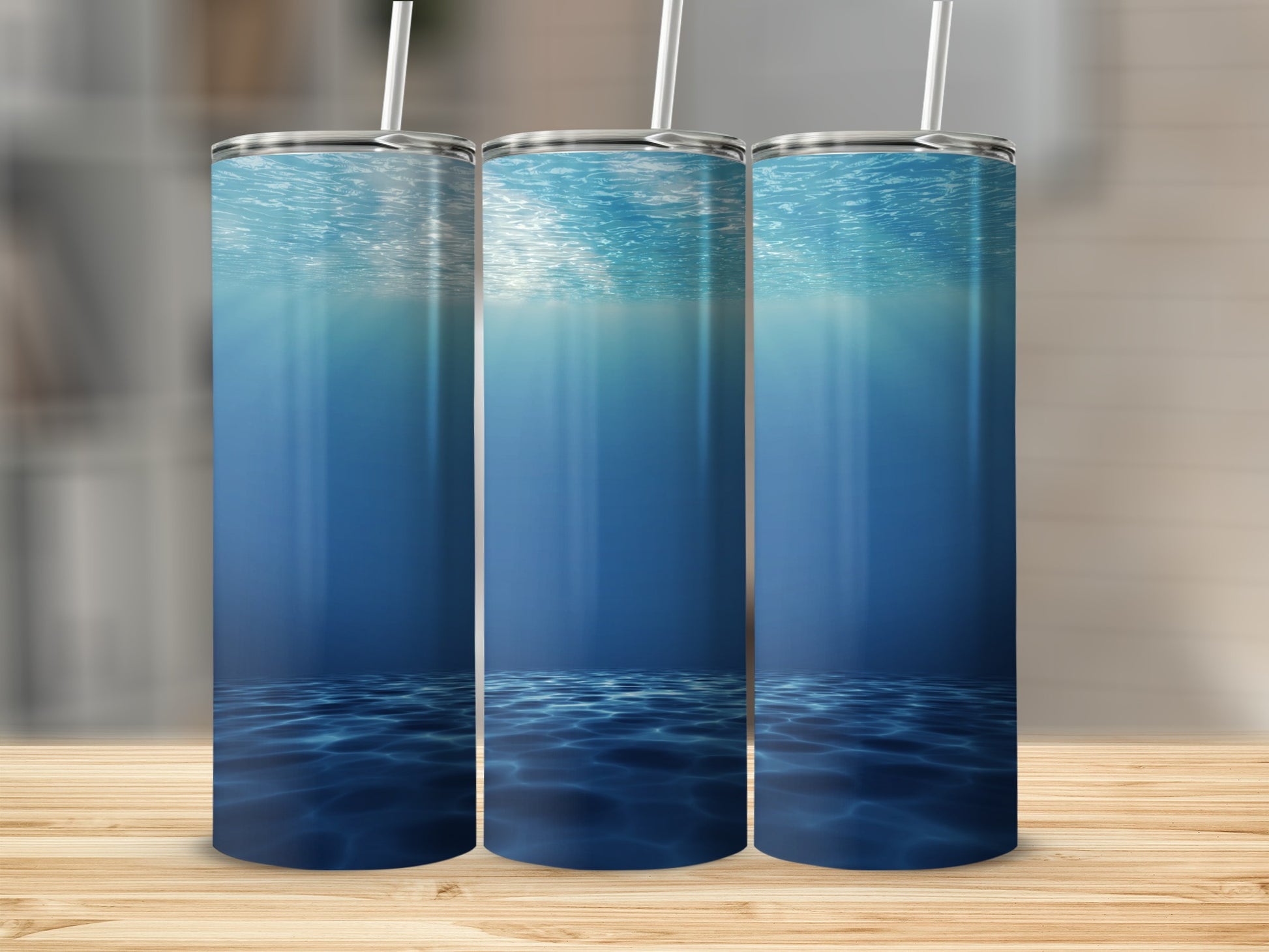 Three tumblers with underwater light rays and rippling water design.