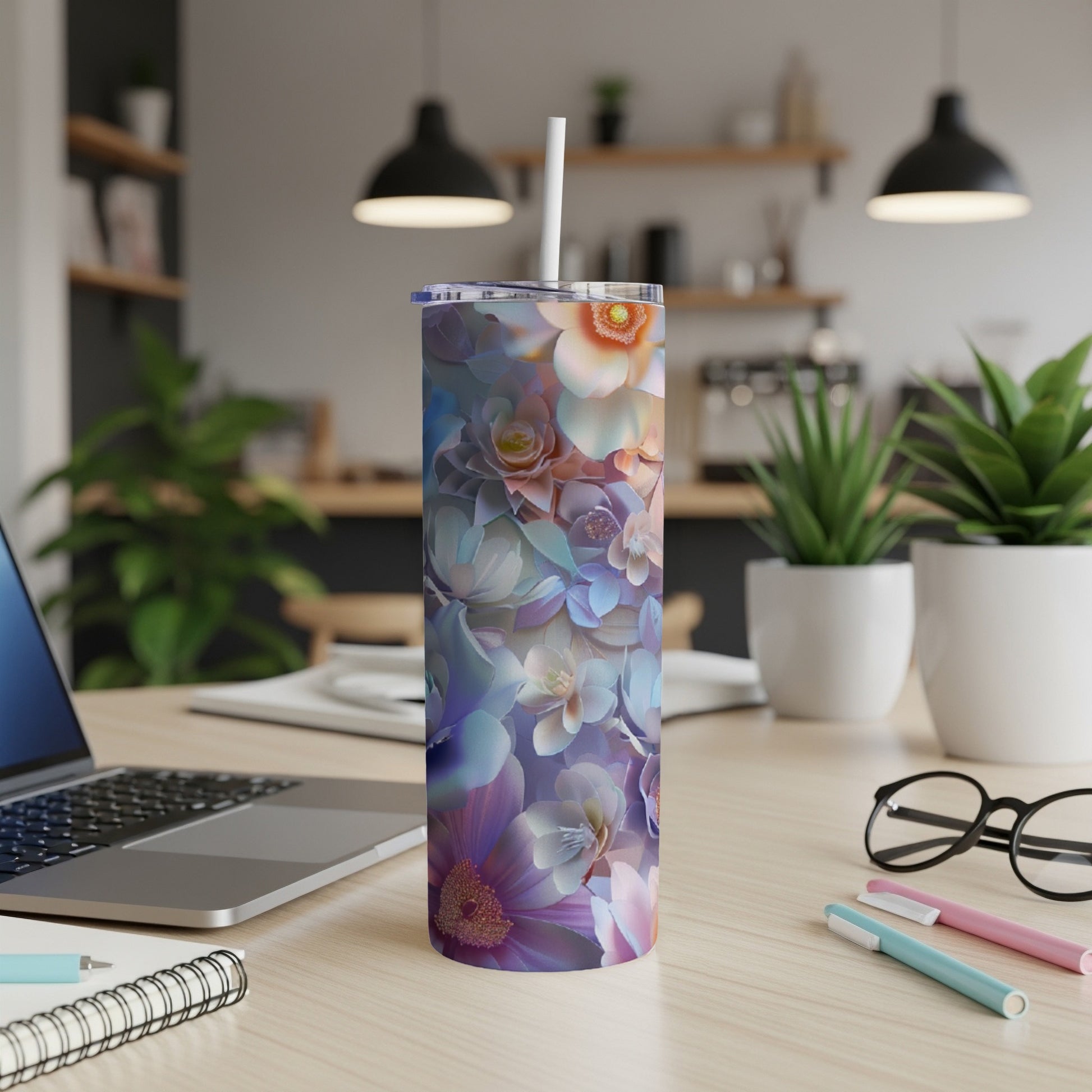 Floral tumbler with straw on a desk.