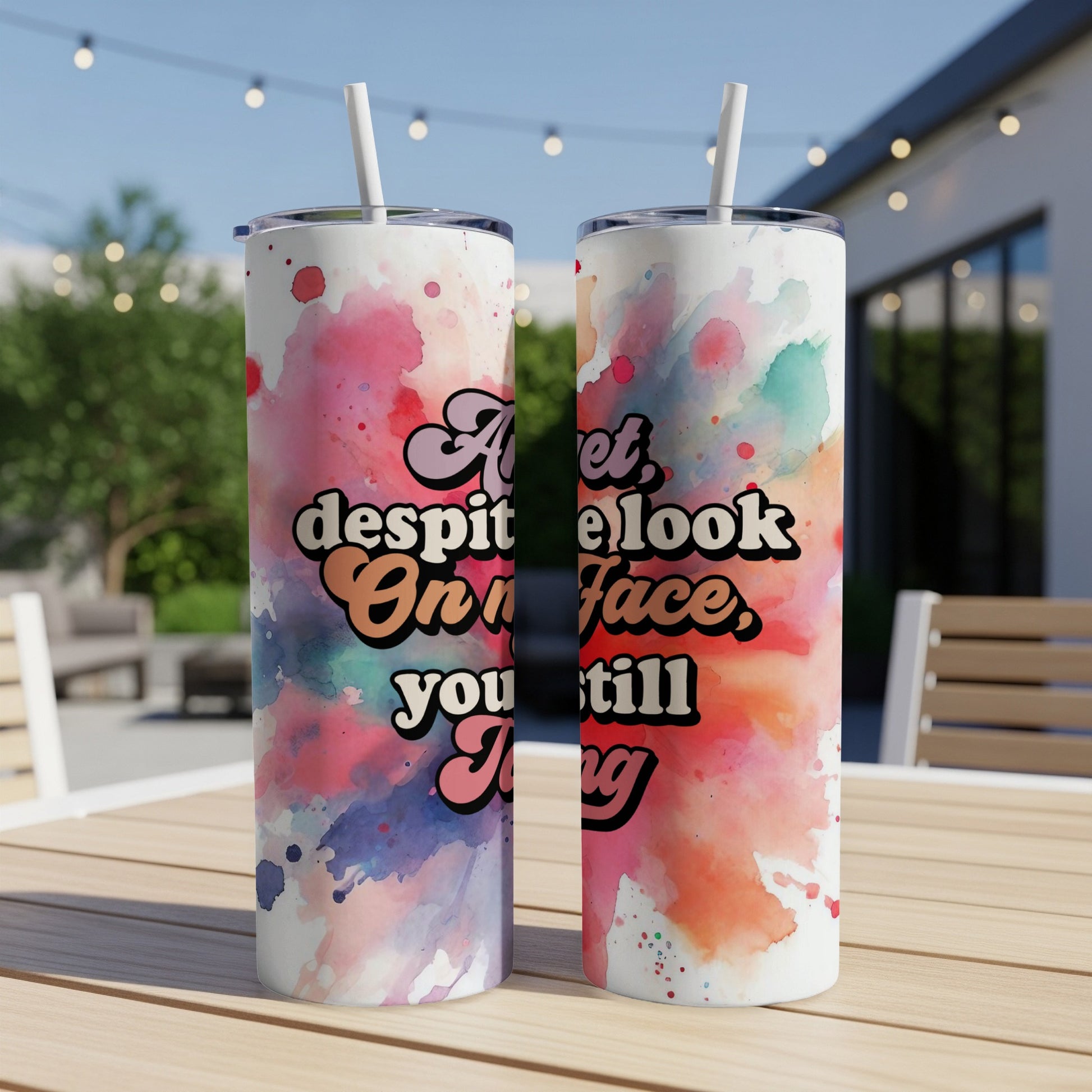 Tumbler with colorful watercolor splash and text "at least look on your face, you still thing".