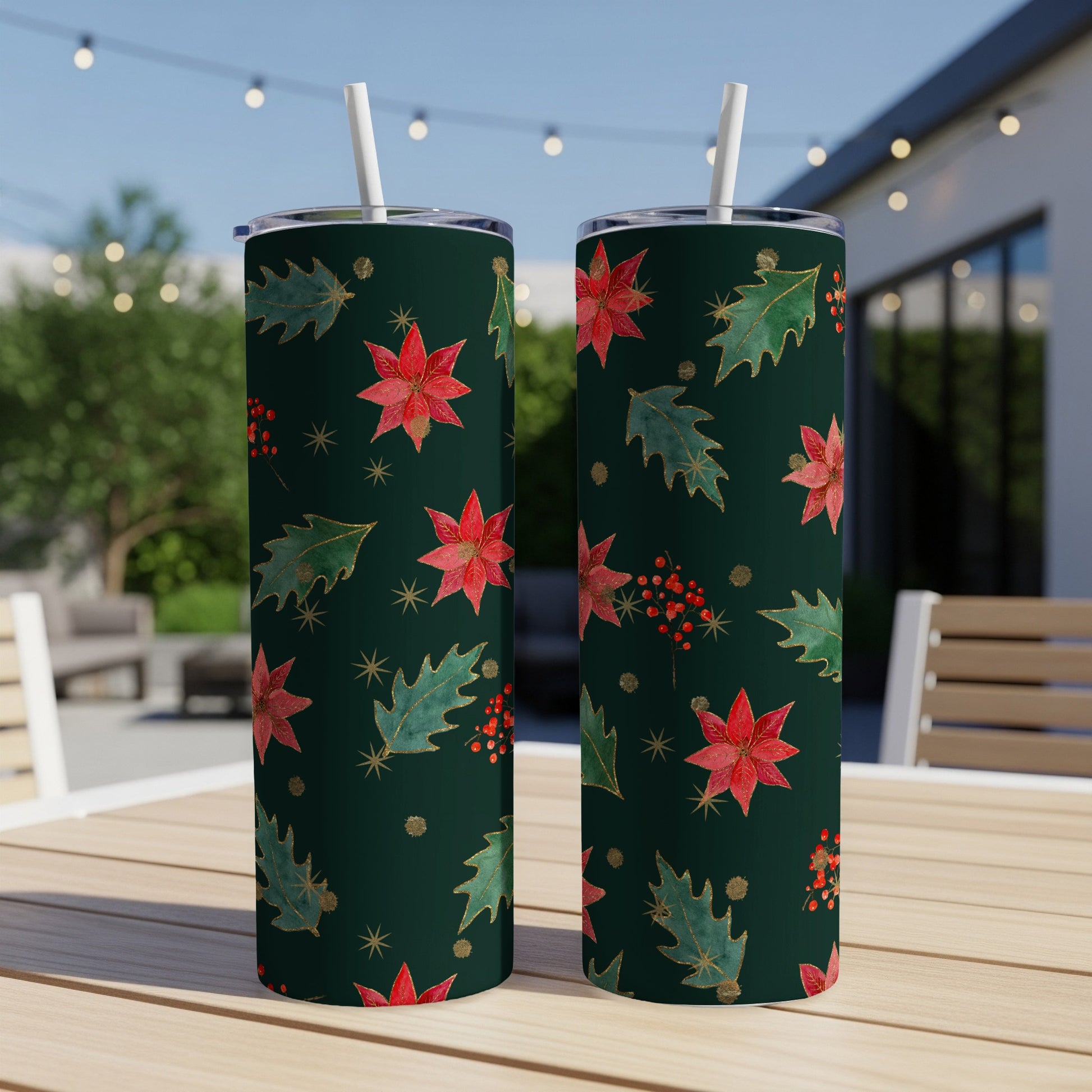 Two dark green tumblers with poinsettia, holly, and berry Christmas pattern.