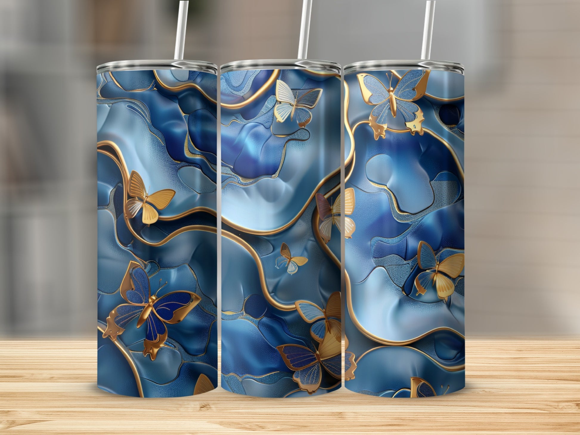 Blue wavy tumbler with gold butterflies and straws, set on a wooden surface.