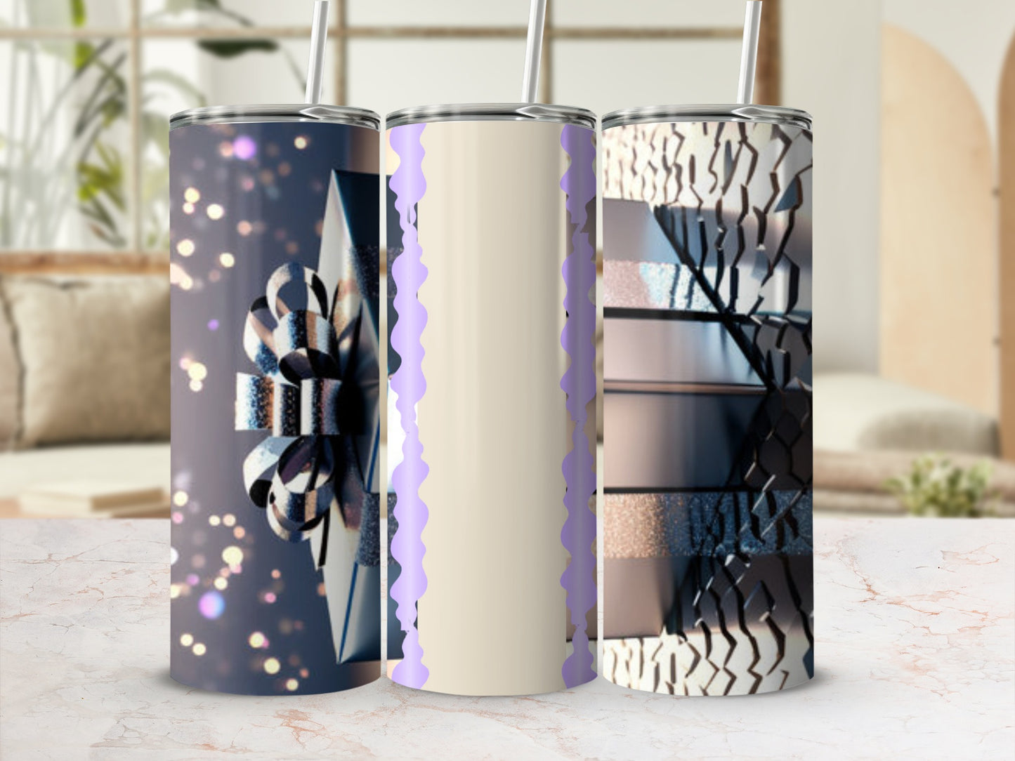 Three tumblers with abstract designs and straw, displayed on a marble surface.