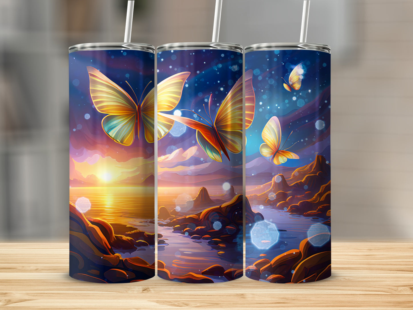 Three tumblers with butterflies and sunset landscape designs.